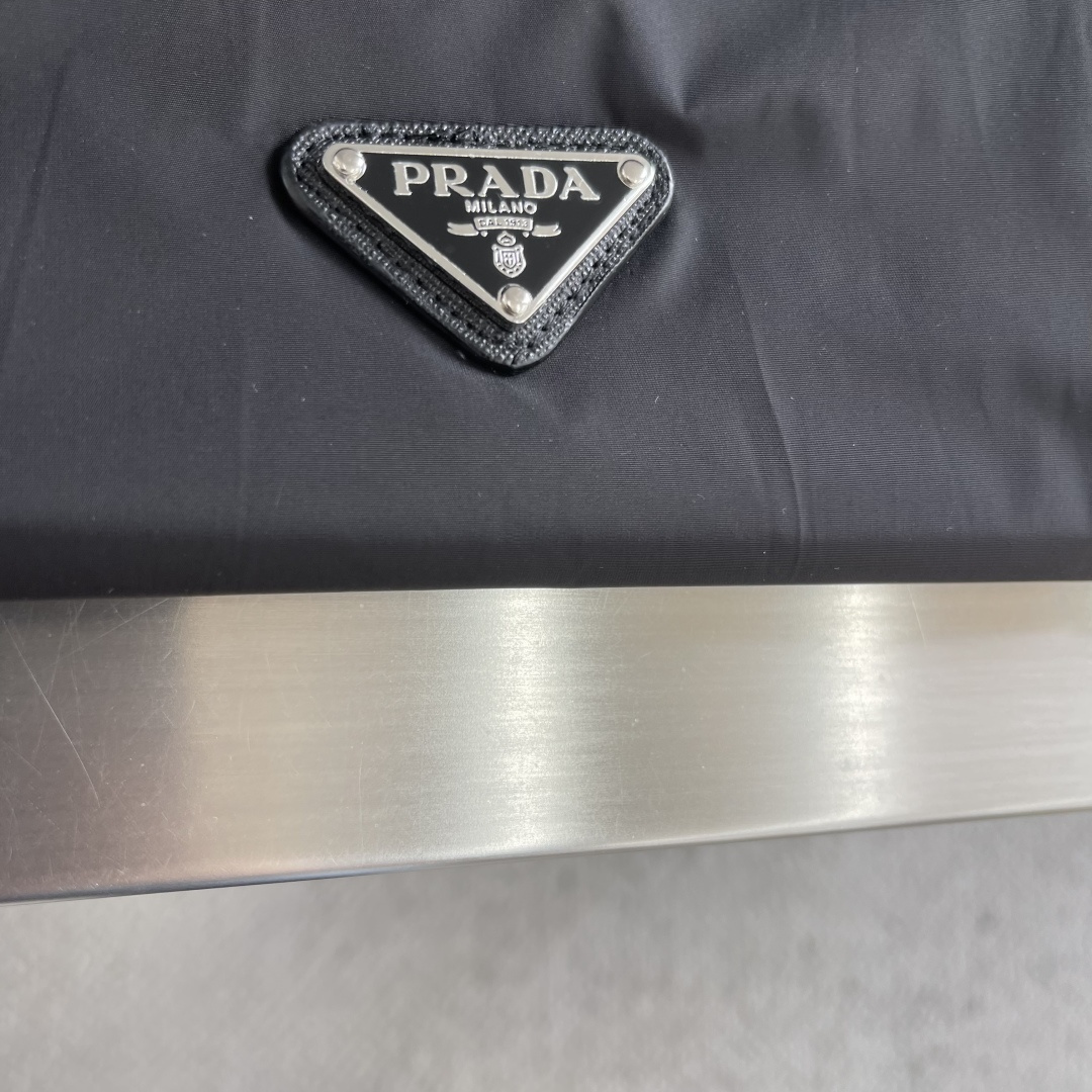 -PRAD 26早春新款连帽夹克胸前搭配标志性珐琅三角徽章标识，属于灵魂式点缀，夹克属于过渡季优秀的装备