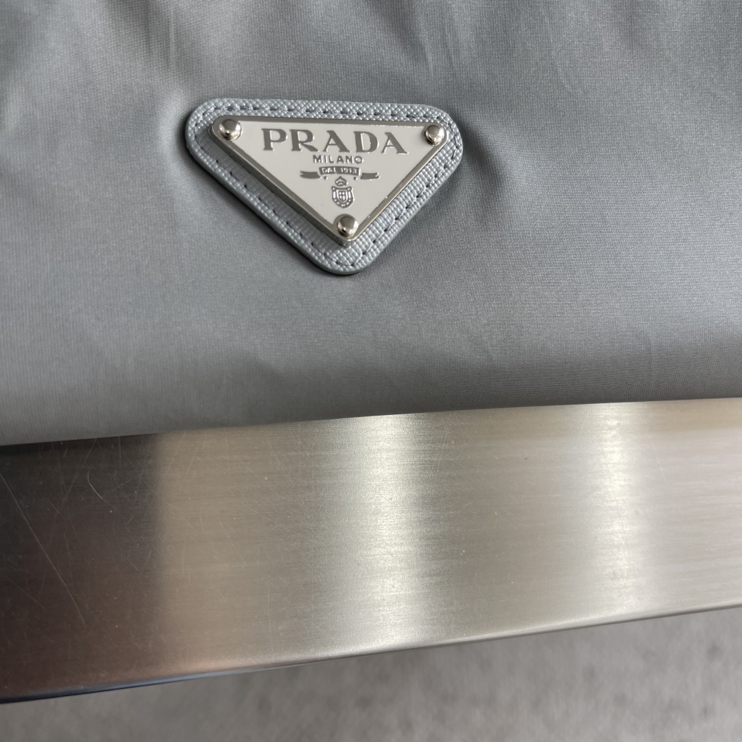 -PRAD 26早春新款连帽夹克胸前搭配标志性珐琅三角徽章标识，属于灵魂式点缀，夹克属于过渡季优秀的装备