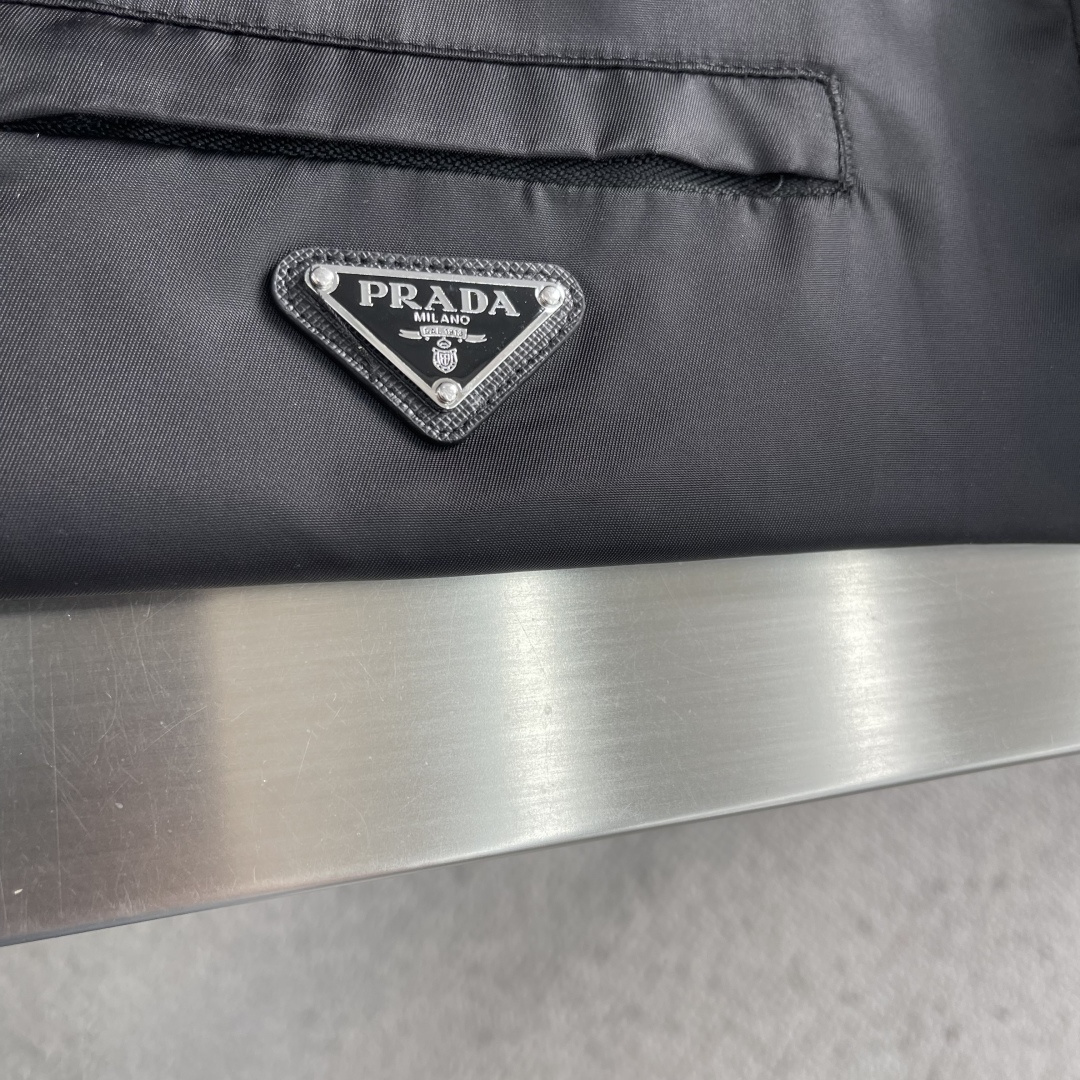 -PRAD 再生尼龙连帽夹克选用品牌标志性的再生尼龙面料，与传统尼龙性能相当，具备高强度，抗撕裂，耐磨损