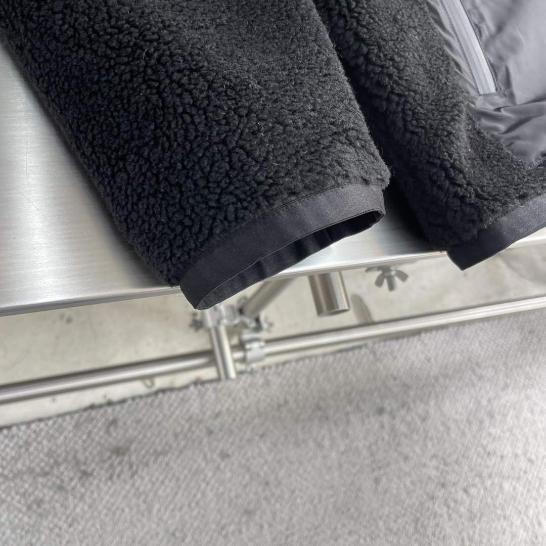 -PRAD 新款双面穿连帽夹克。这款夹克采用摇粒绒与防风面料拼接设计，兼具保暖性与机能感。胸前红色品牌标