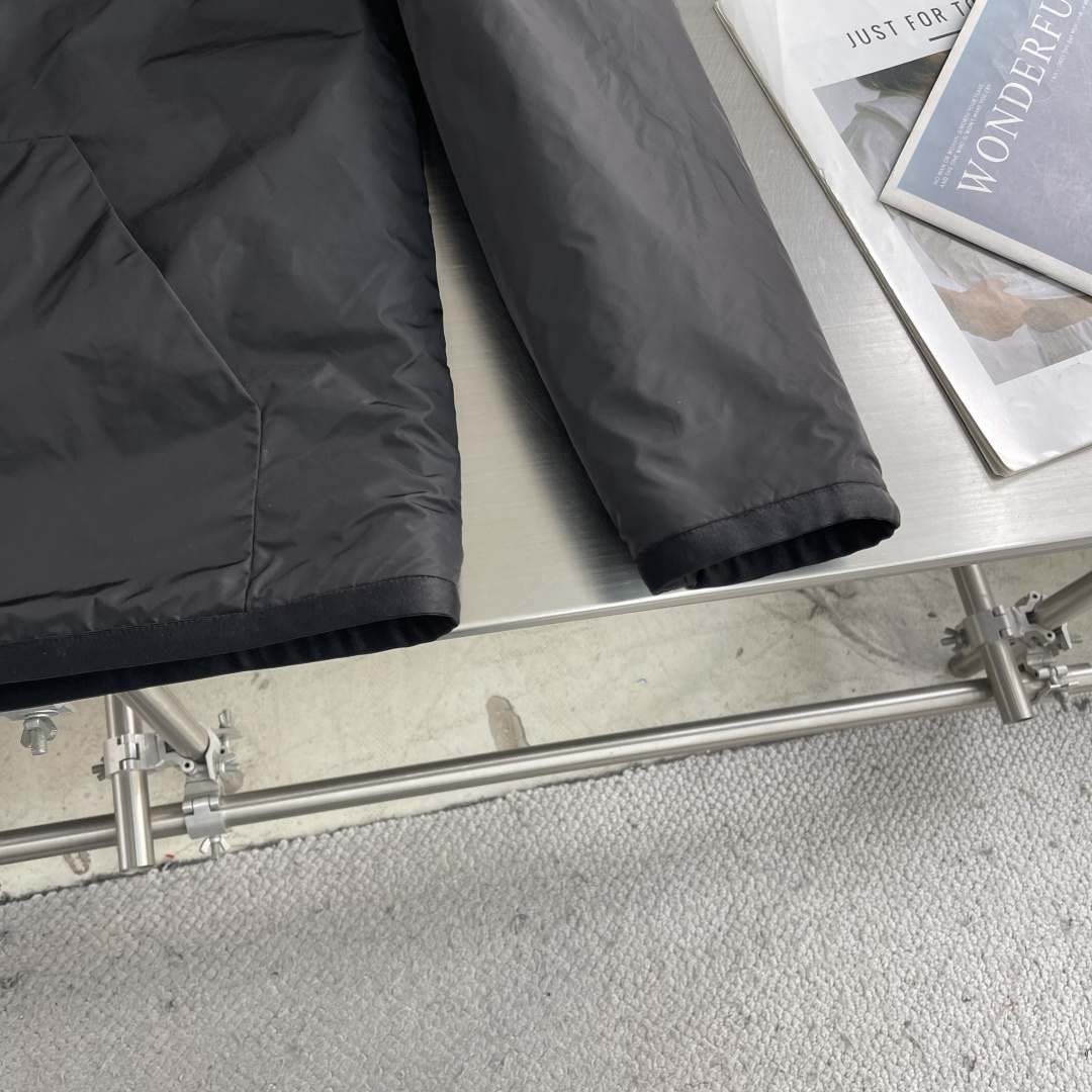 -PRAD 新款双面穿连帽夹克。这款夹克采用摇粒绒与防风面料拼接设计，兼具保暖性与机能感。胸前红色品牌标