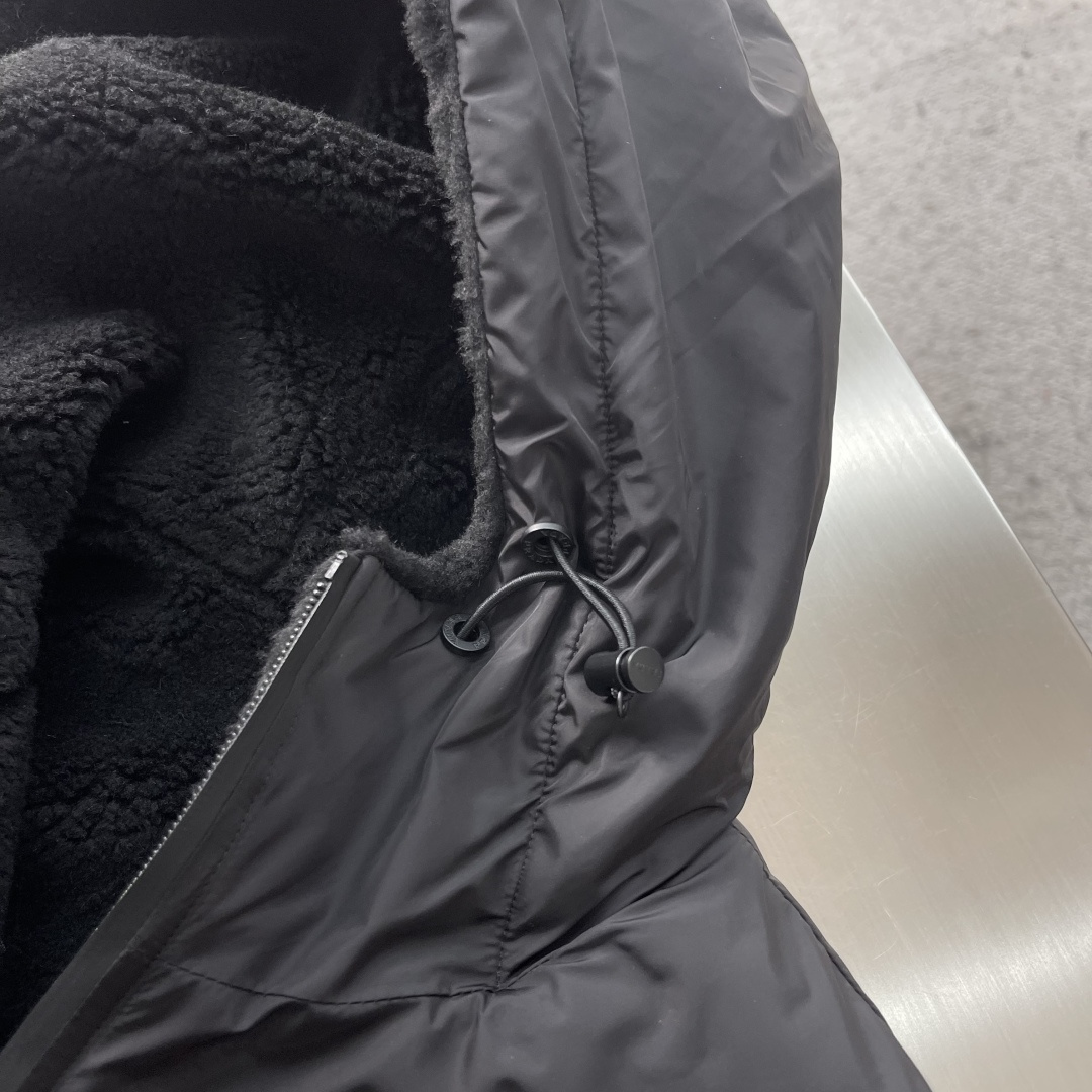 -PRAD 新款双面穿连帽夹克。这款夹克采用摇粒绒与防风面料拼接设计，兼具保暖性与机能感。胸前红色品牌标