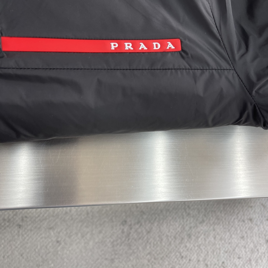 -PRAD 新款双面穿连帽夹克。这款夹克采用摇粒绒与防风面料拼接设计，兼具保暖性与机能感。胸前红色品牌标