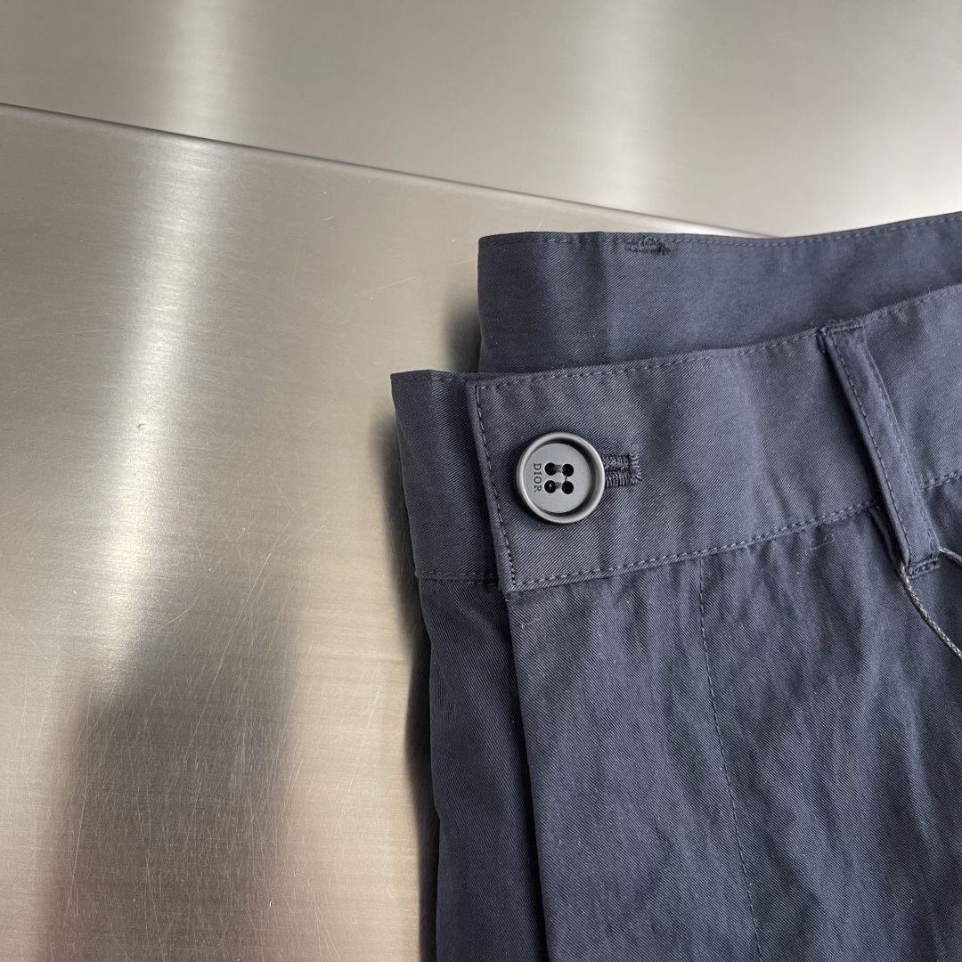 -Dio 新款深蓝色工装裤。经典直筒剪裁，两侧大口袋设计，左腿口袋处有品牌刺绣Logo，整体风格兼具机能