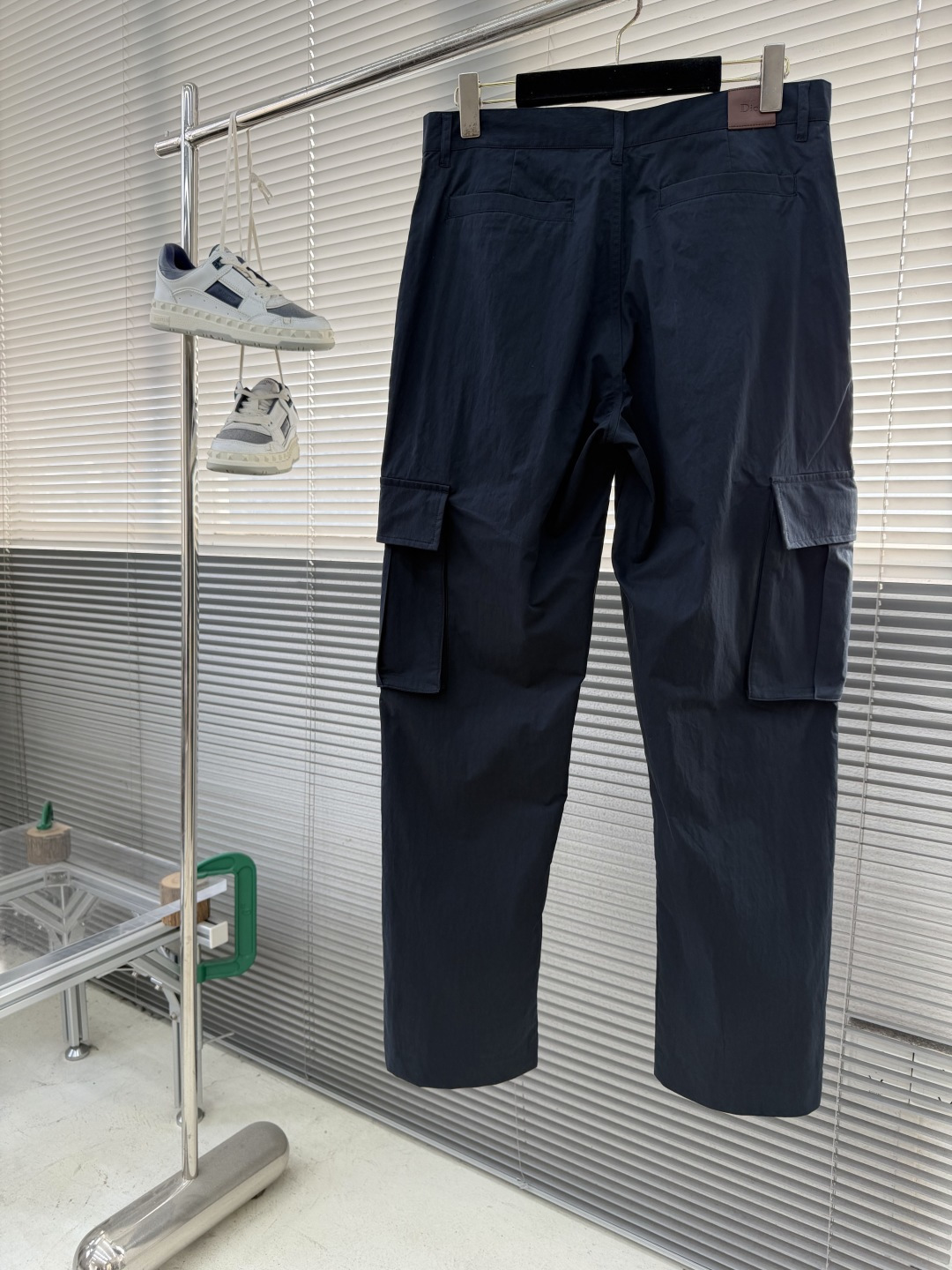 -Dio 新款深蓝色工装裤。经典直筒剪裁，两侧大口袋设计，左腿口袋处有品牌刺绣Logo，整体风格兼具机能