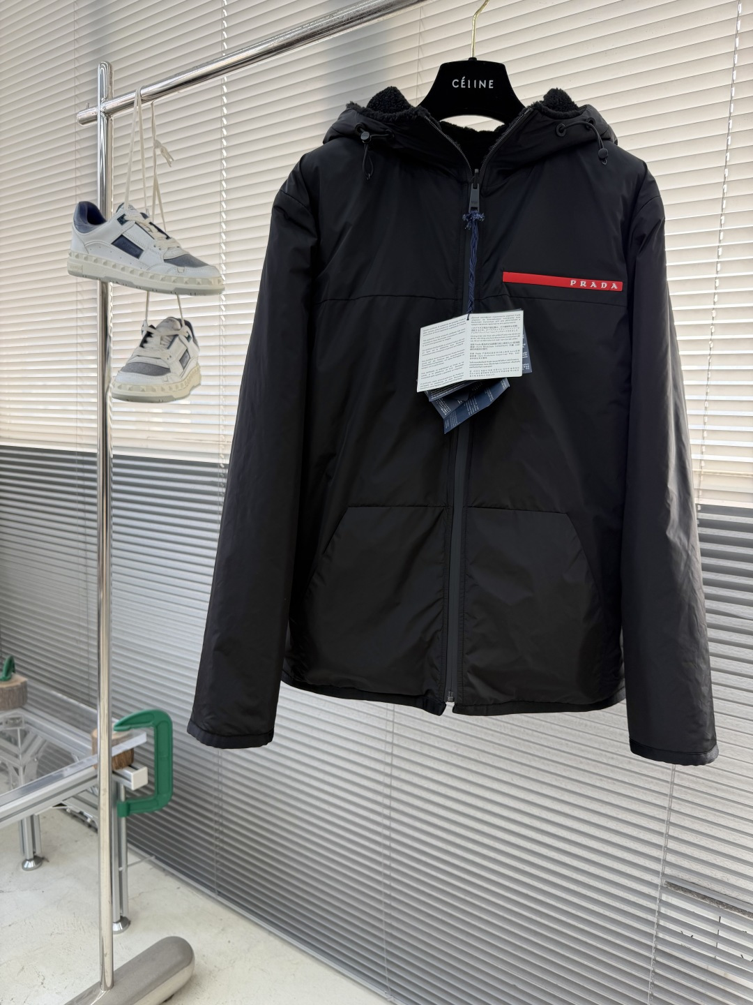 -PRAD 新款双面穿连帽夹克。这款夹克采用摇粒绒与防风面料拼接设计，兼具保暖性与机能感。胸前红色品牌标