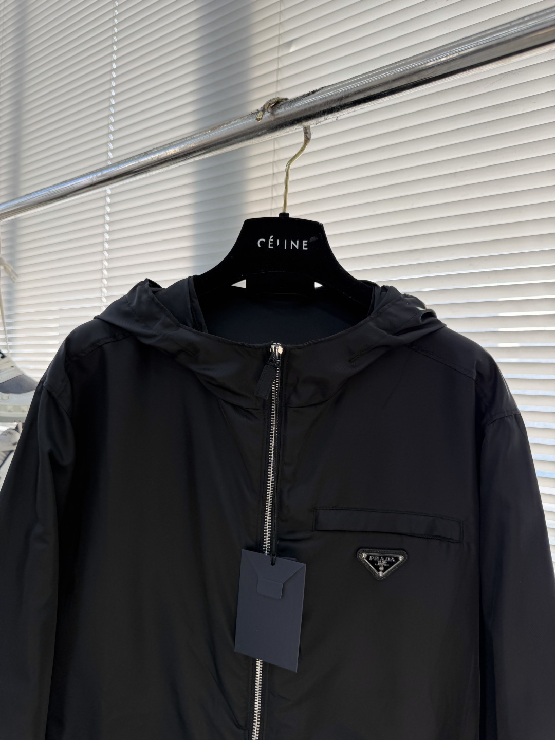 -PRAD 再生尼龙连帽夹克选用品牌标志性的再生尼龙面料，与传统尼龙性能相当，具备高强度，抗撕裂，耐磨损