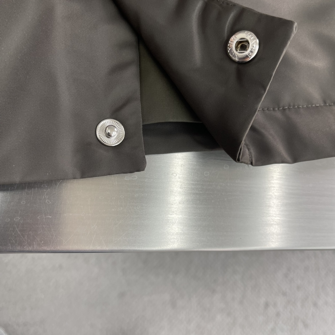 -PRAD 新款三角微标夹克。这款夹克采用高品质尼龙，罗纹领口和袖口，弹力下摆，防风防水又保暖，简约剪裁