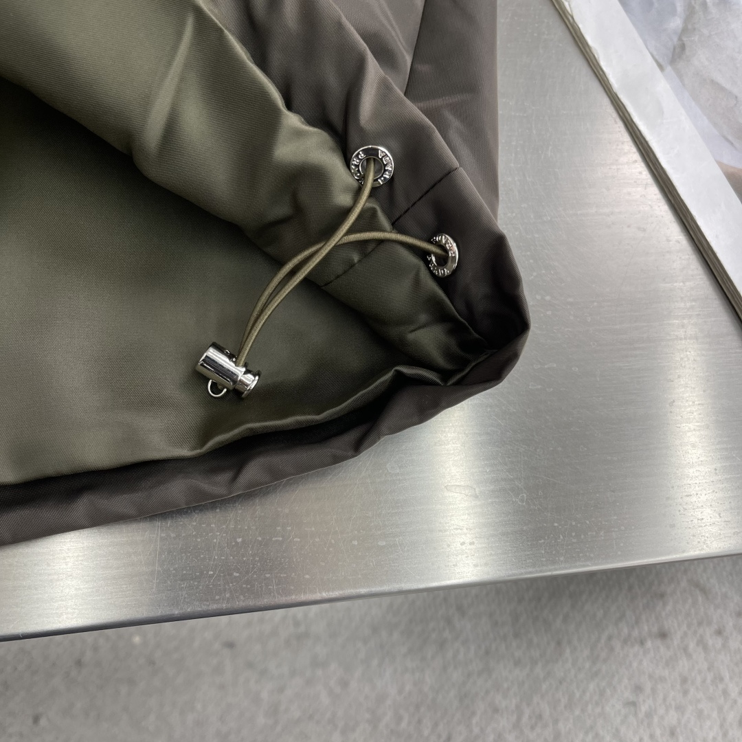 -PRAD 新款三角微标夹克。这款夹克采用高品质尼龙，罗纹领口和袖口，弹力下摆，防风防水又保暖，简约剪裁