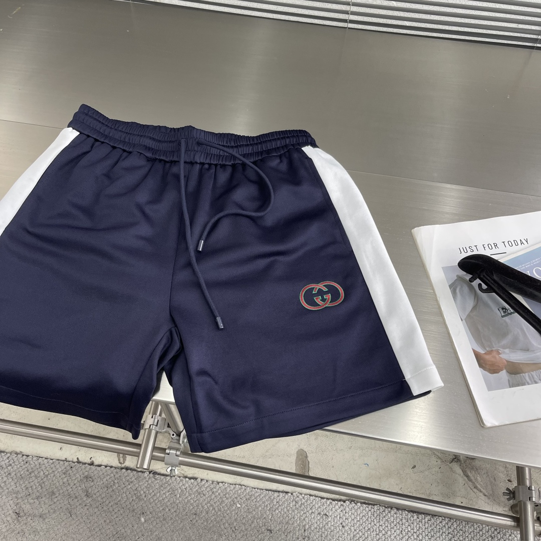 -GUCC 新款刺绣运动短裤。这款深蓝色运动短裤，侧边白色条纹+双G刺绣，品牌感满满!轻质聚酯纤维材质，
