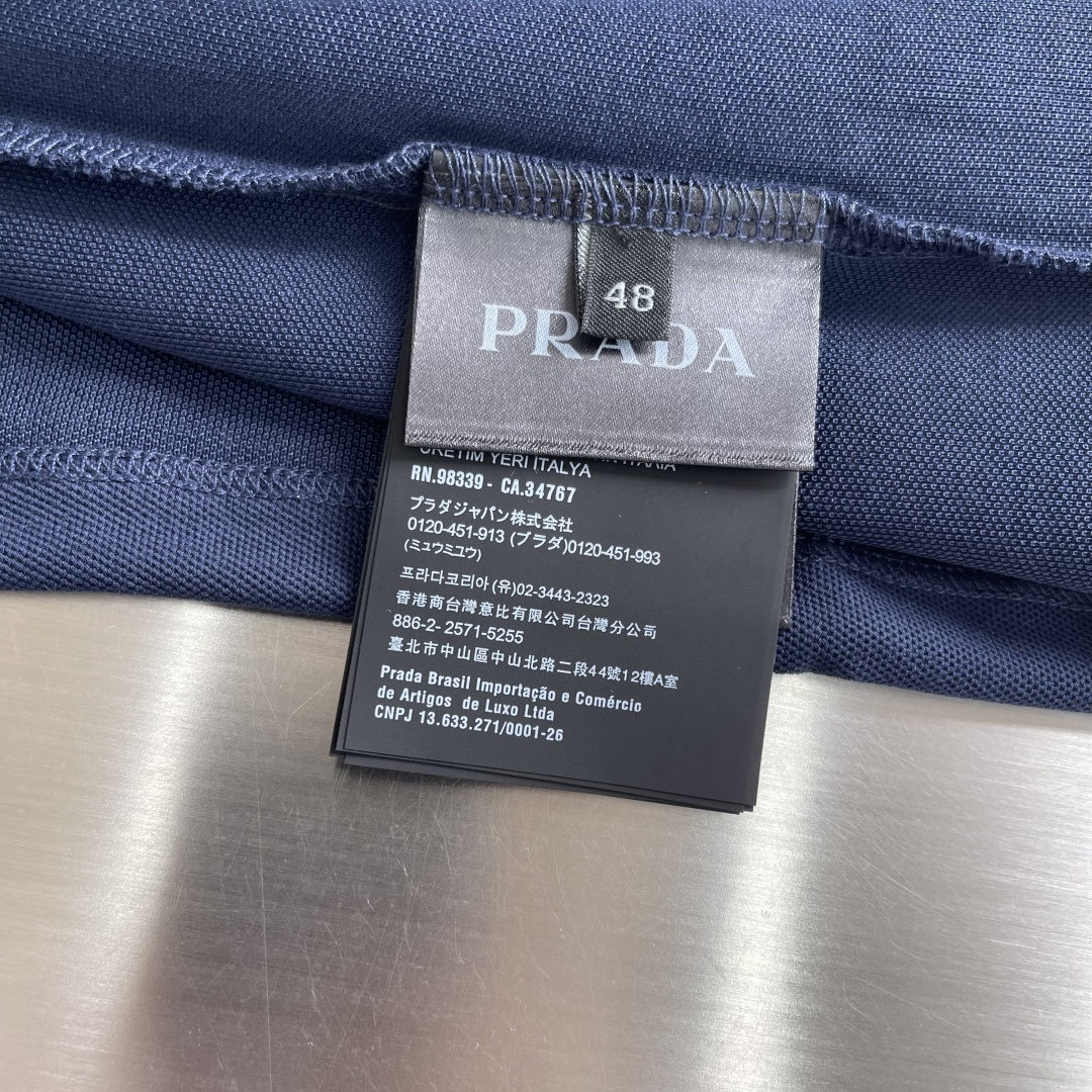 -PRAD 徽标刺绣抽绳Polo衫定制粗颗纹路棉质帆布料 紧密细腻 高端精致 以一抹澄澈的浅蓝惊艳亮相 