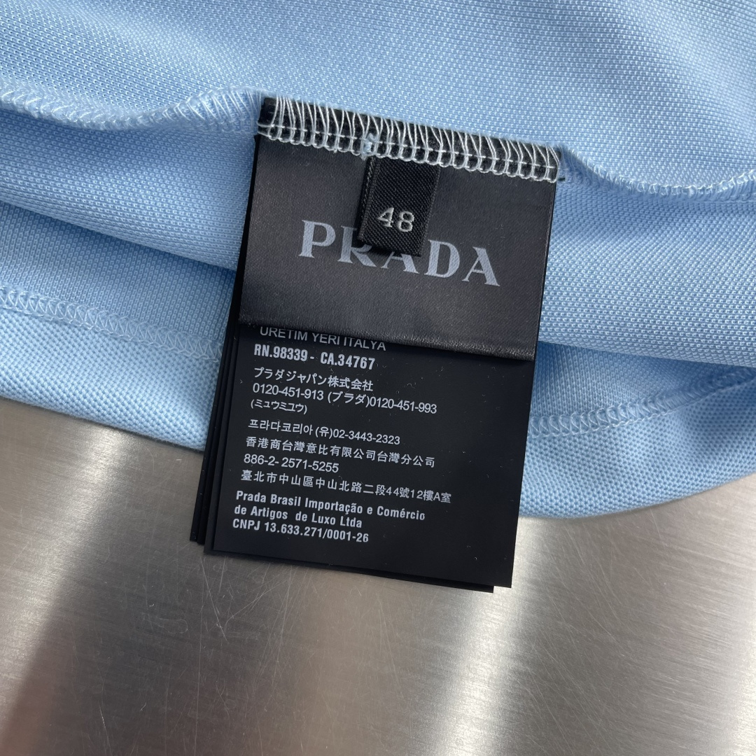 -PRAD 徽标刺绣抽绳Polo衫定制粗颗纹路棉质帆布料 紧密细腻 高端精致 以一抹澄澈的浅蓝惊艳亮相 
