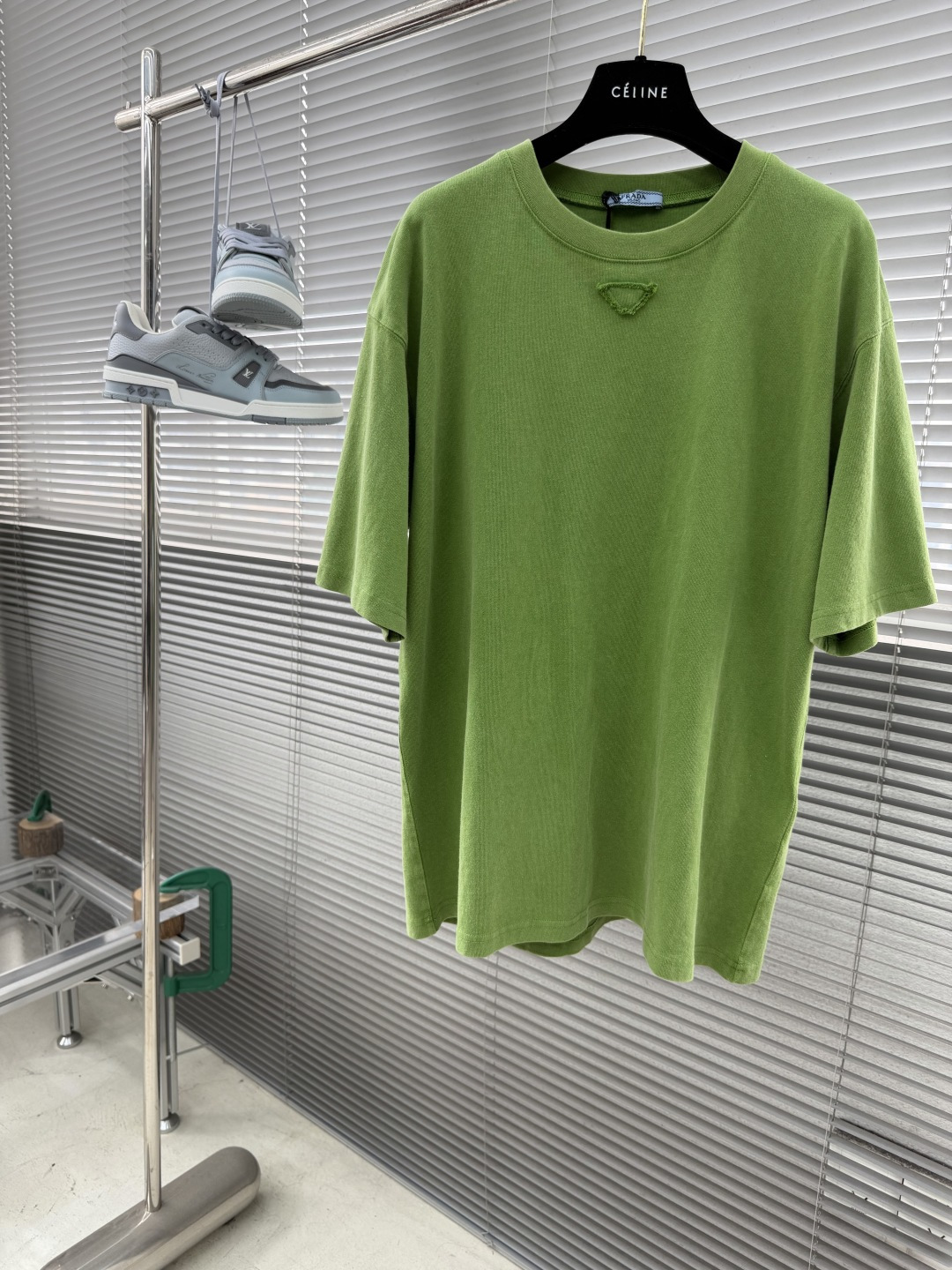 NO:953722,-PRAD 26's new triangle-labeled green round-neck short-sleeved T-shirt is made of 12-count heavyweight combed pure cotton plain fabric, weighing 230g. The fabric texture is rough and full, with strong structural support and skin-friendly breathability. It has been pre-shrunk and enzymatically pre-washed. It has excellent dimensional stability and can effectively resist the risk of deformation and wrinkles caused by daily washing.  The craftsmanship adopts the stir-fried distressing process, combined with stone grinding and enzyme washing, to give the fabric a retro and distressed bamboo texture and a matte matte texture, showing a rich retro grass green tone. The cloth surface has a natural distressed and faded effect, while retaining the natural softness of the cotton fiber.  The silhouette is cut with oversize dropped shoulders and wide sleeves, and the neckline is a double-needle ribbed round collar. It is combined with three-needle seaming technology to enhance the collar's stretch resistance and prevent it from loosening after long-term wear. The iconic triangle logo on the chest is made of the same fabric and three-dimensional sewing technology, with double-needle topstitching to outline the outline, injecting a low-key and luxurious brand recognition on the minimalist plain color base. The cuffs and hem are processed by flat-turn double-needle curling, with neat and neat lines, which perfectly integrates minimalist industrial style aesthetics and advanced garment technology.  Size S.M.L.XL Length 71727374 Bust 110 114 122 Shoulder width 50525456, prada, versace, T-shirt, tees, t-shirt,19860909-PRAD 26新款三角标绿色圆领短袖T恤 采用12支重磅精梳纯棉平纹面料织造,克重达230g,布面肌理粗犷饱满,兼具强韧结构支撑力与亲肤透气性,经预缩定型与酵素预洗处理,尺寸稳定性优异,可有效抵御日常洗涤带来的变形、起皱风险 工艺上采用炒色做旧工艺,通过石磨与酵素洗联合处理,赋予面料复古做旧的竹节肌理与雾面哑光质感,呈现出层次丰富的复古草绿色调,布面自带自然的做旧晕染效果,同时保留棉纤维的天然柔软度 版型上采用Oversize落肩阔袖剪裁,领口为双针罗纹圆领,配合三本针锁边工艺强化领型抗拉伸性,久穿不易松垮；胸前标志性三角标识采用同面料立体车缝工艺,以双针明线勾勒轮廓,在极简素色基底上注入低调奢华的品牌辨识度；袖口与下摆采用平车双针卷边处理,线条利落工整,将极简工业风美学与高级成衣工艺完美融合 码数S.M.L.XL 衣长71727374 胸围 110 114 122 肩宽50525456,,prada,versace,T-shirt,tees，t-shirt,,Men's clothing