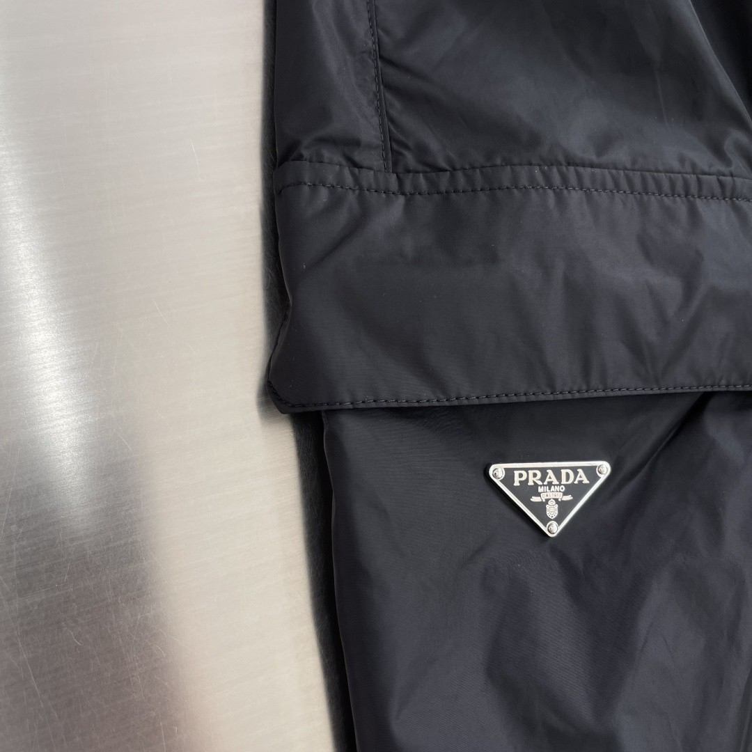 -PRAD 新款三角微标短裤。这款短裤采用流畅动感设计，选用创新的再生尼龙面料，成为Prad*系列的元素