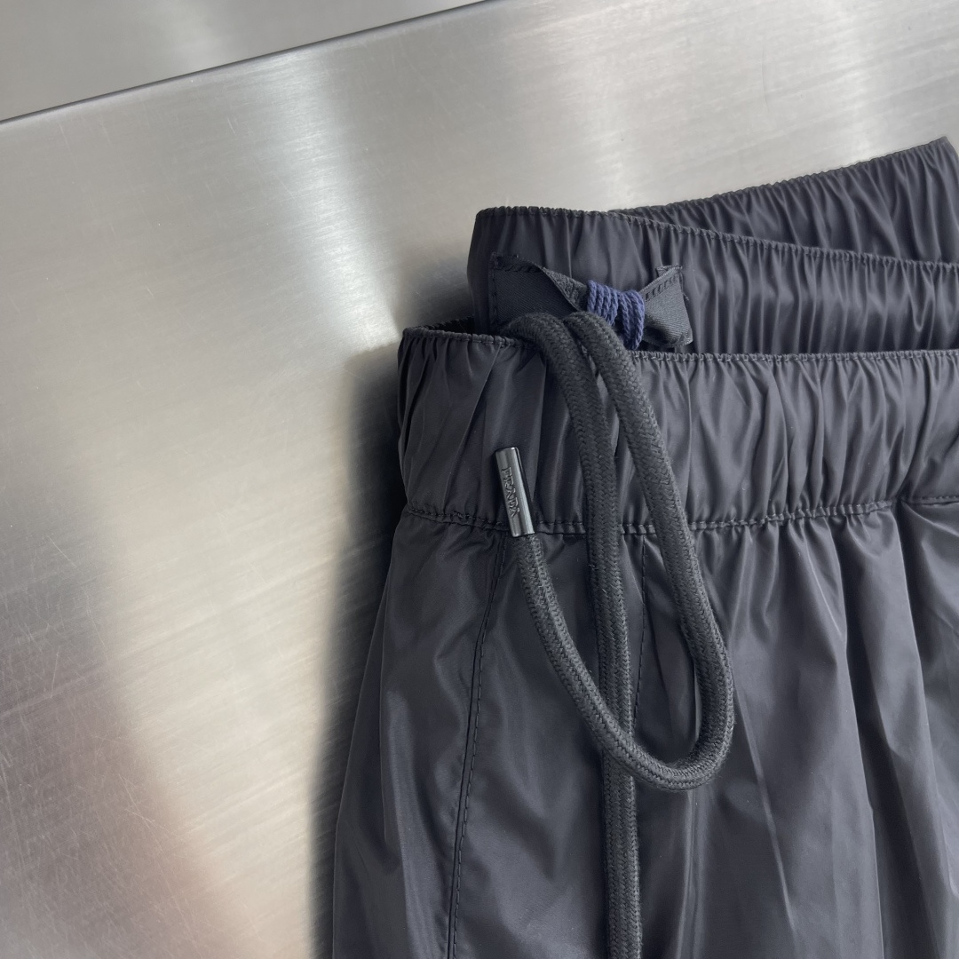 -PRAD 新款三角微标短裤。这款短裤采用流畅动感设计，选用创新的再生尼龙面料，成为Prad*系列的元素