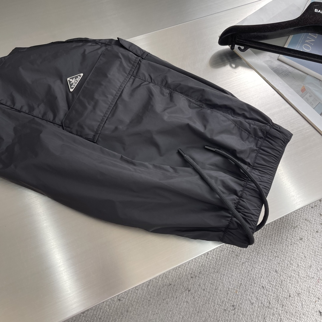 -PRAD 新款三角微标短裤。这款短裤采用流畅动感设计，选用创新的再生尼龙面料，成为Prad*系列的元素