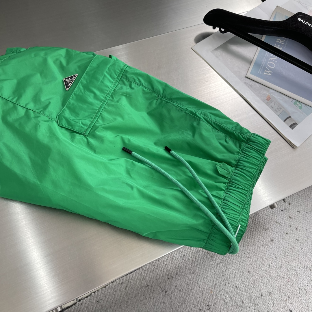 -PRAD 新款三角微标短裤。这款短裤采用流畅动感设计，选用创新的再生尼龙面料，成为Prad*系列的元素