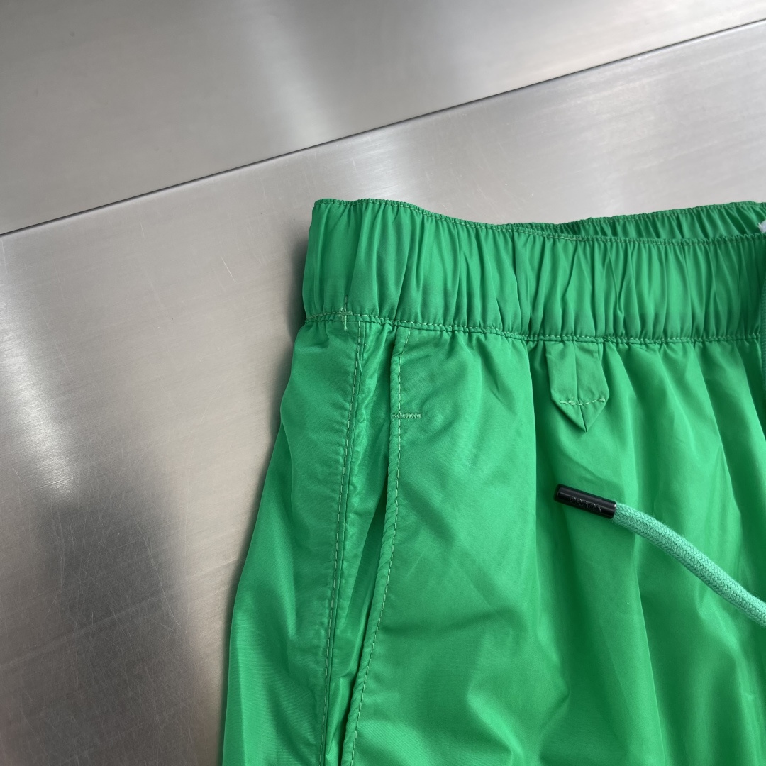 -PRAD 新款三角微标短裤。这款短裤采用流畅动感设计，选用创新的再生尼龙面料，成为Prad*系列的元素