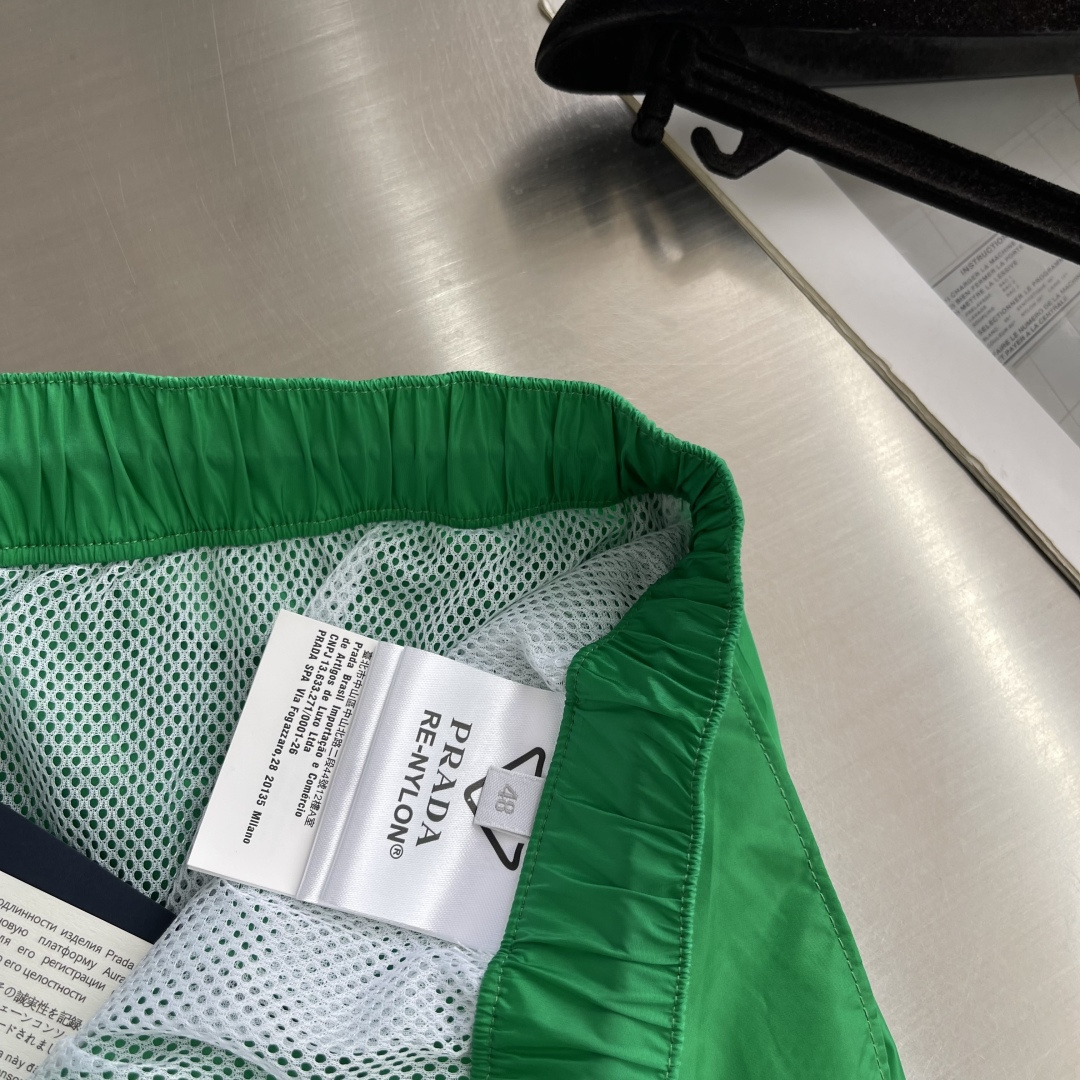 -PRAD 新款三角微标短裤。这款短裤采用流畅动感设计，选用创新的再生尼龙面料，成为Prad*系列的元素