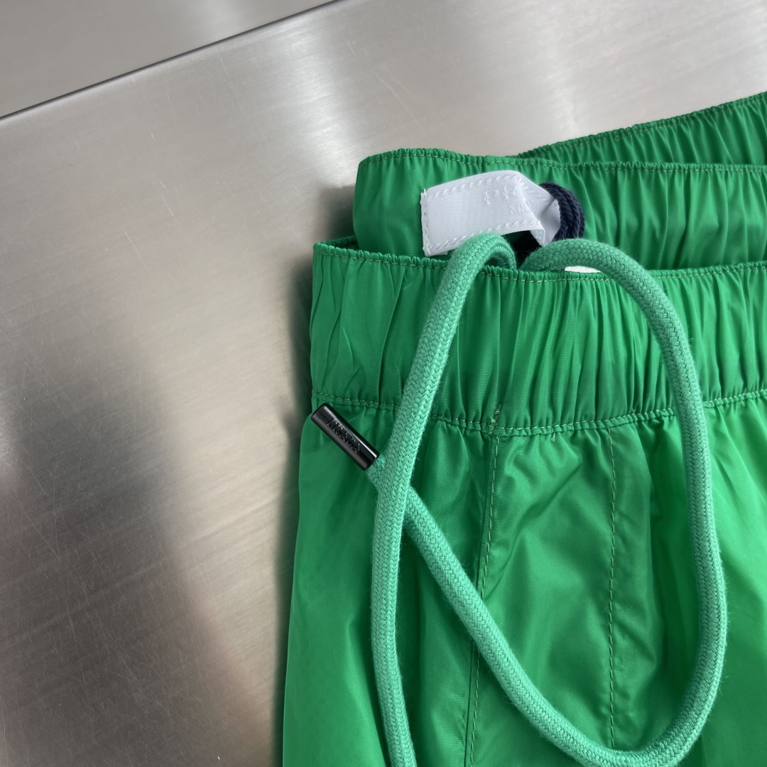 -PRAD 新款三角微标短裤。这款短裤采用流畅动感设计，选用创新的再生尼龙面料，成为Prad*系列的元素