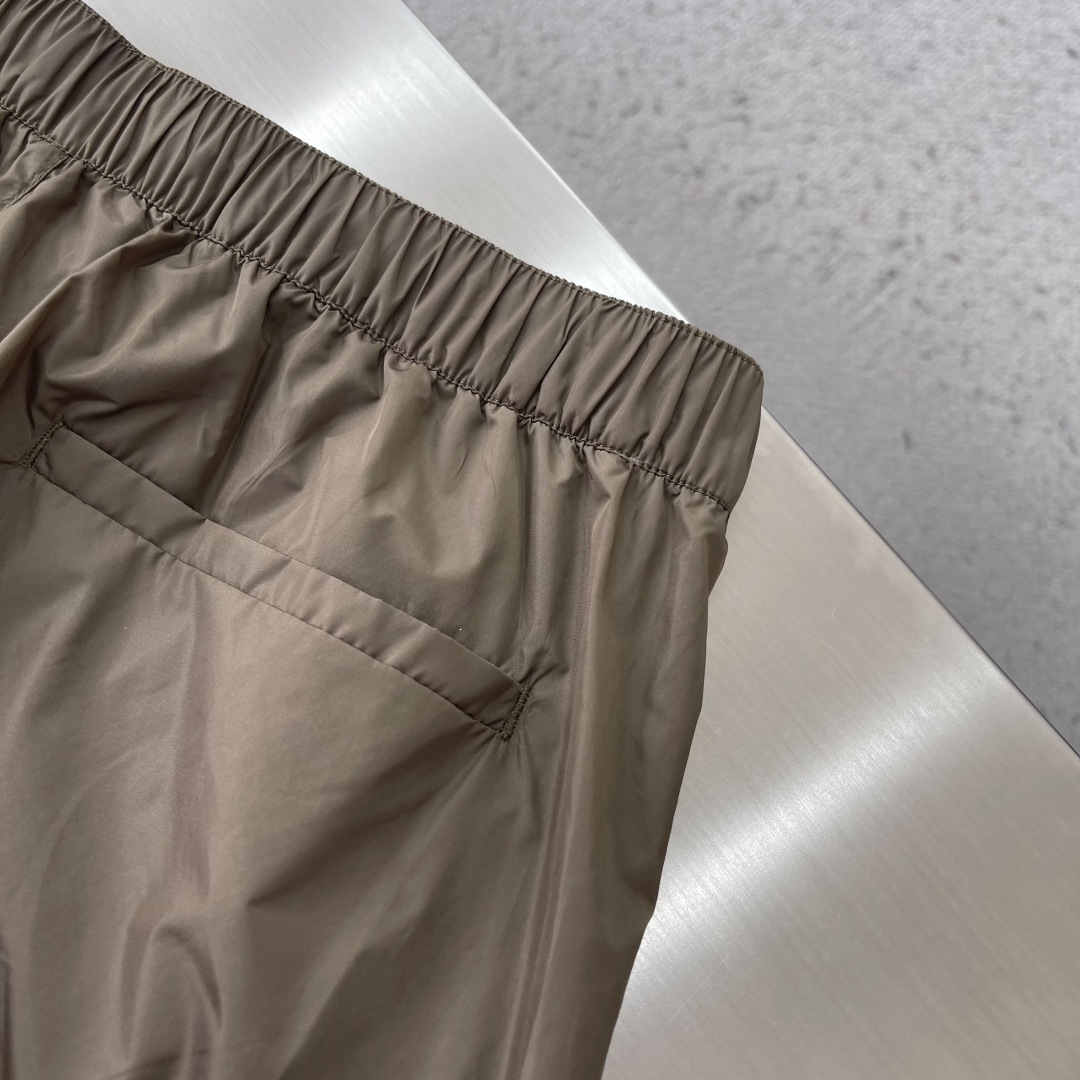 -PRAD 新款三角微标短裤。这款短裤采用流畅动感设计，选用创新的再生尼龙面料，成为Prad*系列的元素