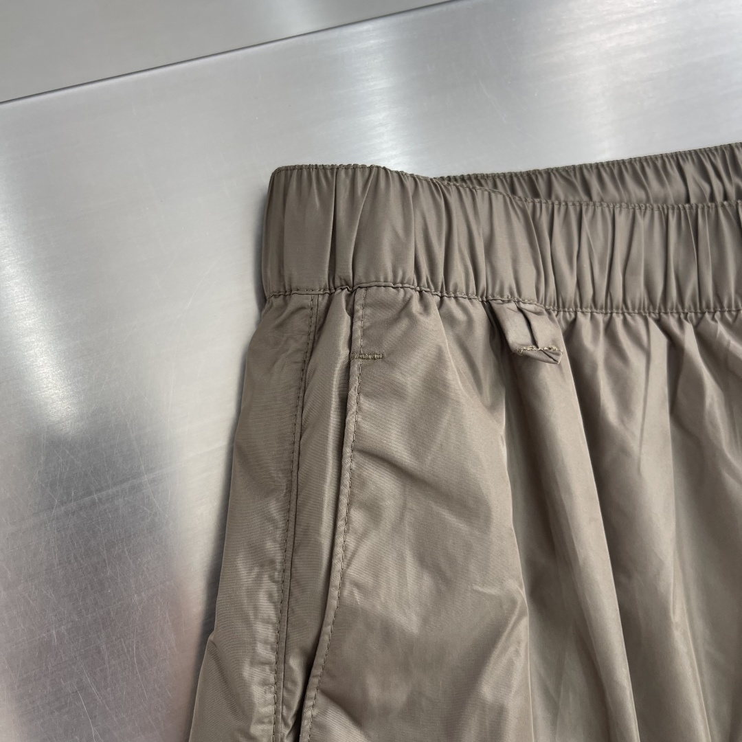 -PRAD 新款三角微标短裤。这款短裤采用流畅动感设计，选用创新的再生尼龙面料，成为Prad*系列的元素