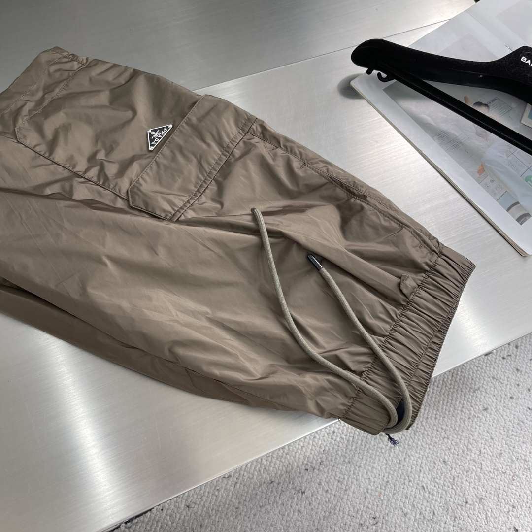 -PRAD 新款三角微标短裤。这款短裤采用流畅动感设计，选用创新的再生尼龙面料，成为Prad*系列的元素