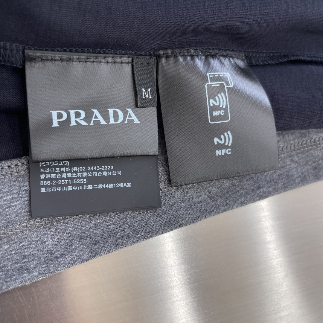 -PRAD     假两件三角标短袖甄选高支长绒精梳棉面料作为衣身主料。棉纤维透气排汗性能优，能快速导出