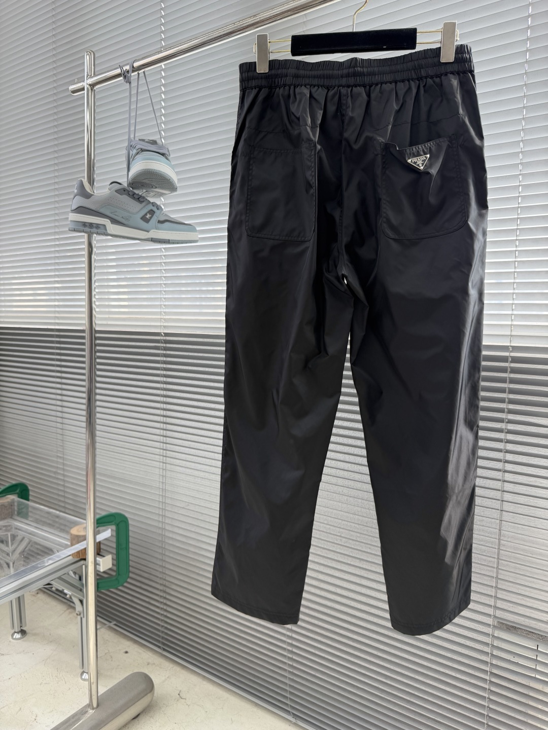 -PRAD    三角微标直筒休闲裤。这款三角标工装直筒裤采用黑色面料，轻质透气，适合户外徒步和日常通勤