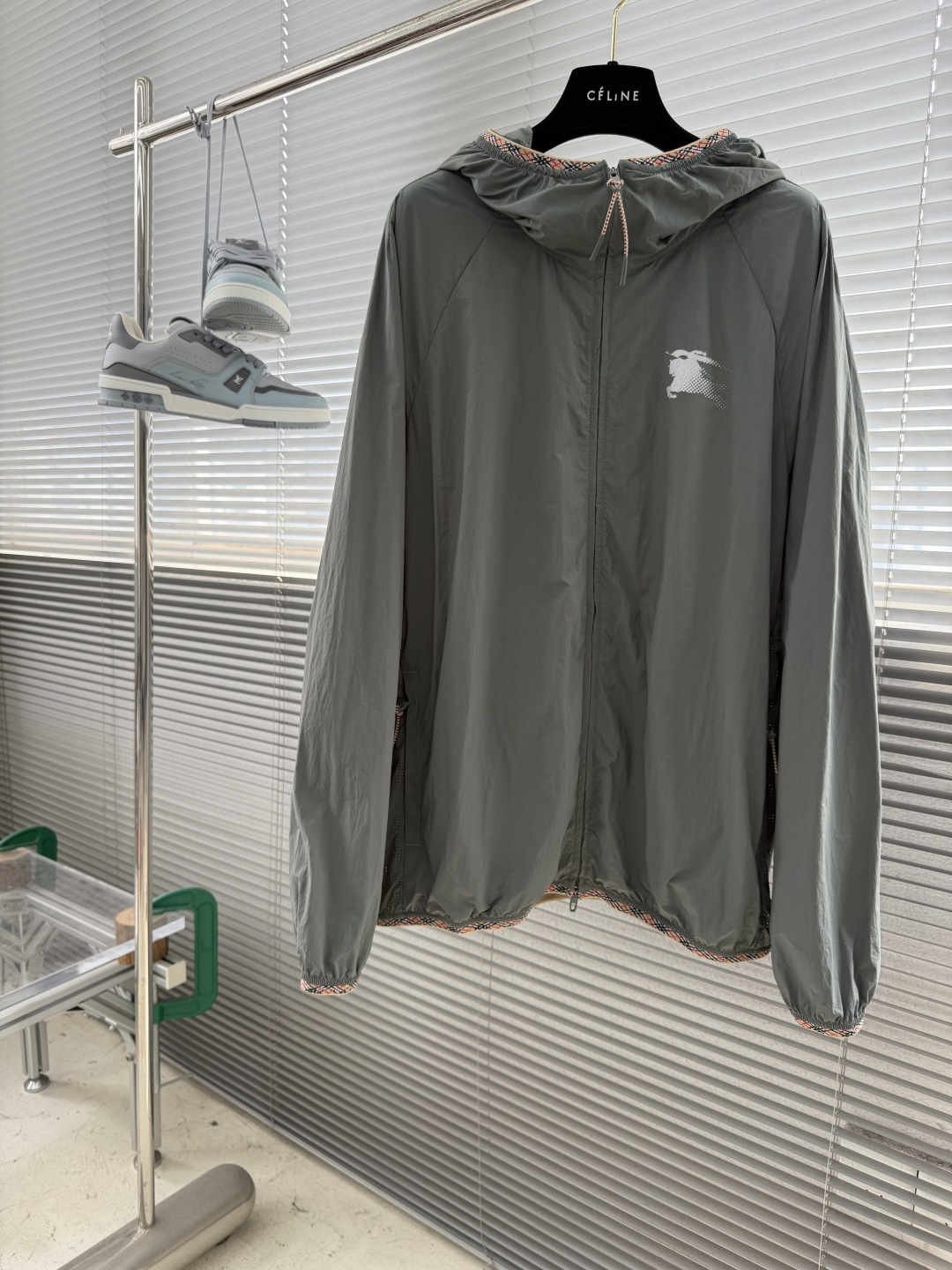 NO:912763,-BBR plaid punched hooded sun protection jacket is made of polyamide fiber fabric with 15D ultra-fine denier filament. It weighs only 45 grams per square meter and is lightweight and portable. Through air deformation process and alkali reduction treatment, it breaks the stiffness of traditional nylon and feels as soft and smooth as clouds. It also retains wear-resistant and anti-wrinkle properties, and its strength is significantly improved. The 2800-needle high-density weaving process achieves functions such as wind and sun protection, ensuring functionality while presenting a delicate texture. A high-precision laser punching process is used to create a classic plaid pattern on lightweight nylon fabric. The 0.1mm micron-level aperture is accurately distributed, and the air circulation rate is increased by 40. The CNC system controls the laser head to fuse the fiber at a frequency of 800 times/second, forming a smooth burr-free hole edge to avoid snag deformation. The punching density gradually changes with the depth of the plaid pattern, which not only enhances the three-dimensional light and shadow effect, but also improves breathability, achieving the perfect integration of functionality and aesthetics. The printer uses a 300-mesh screen to squeegee the primer with light pressure to fill the pores in the nylon fabric, and then uses a 200-mesh thick screen to print the reflective slurry mixed with 80 high-refractive index glass beads to ensure the reflective brightness effect and control overprinting errors throughout the process. It is made within 0.1mm, and the details such as the logo spear and shield are complete and clear. After printing, it is pre-baked at 60°C for 30 seconds and cured at 120°C for 2 minutes. The glue and fiber form a covalent bond, which is resistant to washing for more than 20 times and is stretched for 150 degrees without cracking. For collar label gradient printing, the pattern is first converted into 175 lines of half-tone dots, with a smooth transition of density from 10 to 90. It is matched with an ultra-fine screen and a 65° hardness scraper, and is overprinted in 3 times with the scraping angle offset by 15° each time to achieve a natural color transition. Finally, thermosetting disperse dyes are selected. After hot pressing at 150°C, the dye penetrates into the fiber, which does not destroy the light texture of the fabric at all, and avoids the decrease in strength caused by pinholes. The zipper puller is made of multi-colored yarn interwoven into a plaid pattern, echoing the plaid webbing on the hem and cuffs; a blue TPU injection molded cap is installed at the end of the rope, which feels warm and moist to the touch and prevents it from coming off. The elastic bands on the cuffs and hem have built-in high-elastic spandex yarn, which can be restored to its original shape after a stretch rate of 150; the plaid webbing at the edges is woven with a high density of 16 needles/inch, and the splicing between the webbing and the body is chain-stitched with a pitch of 0.1mm, and the stitches are as smooth as silk. Size SMLXL Size Bust Length Raglan Sleeve Length S6912079 M 70.5 124 80 L7212881 XL 73.5 13282,,jackets & coats,hats,19860909-BBR 格纹状冲孔连帽防晒外套 选用聚酰胺纤维面料以15D超细旦长丝打造,每平方米仅45克重,轻盈便携.通过空气变形工艺与碱减量处理,打破传统尼龙僵硬感,触感如云朵般柔软顺滑,同时保留耐磨抗皱特性,强度显著提升.2800针高密织造工艺,实现防风防晒等功能,在确保功能性的同时呈现细腻质感. 采用高精度激光冲孔工艺,在轻盈尼龙面料上打造经典格纹图案.0.1mm微米级孔径精准分布,空气流通量提升40.数控系统控制激光头以800次/秒频率熔断纤维,形成光滑无毛刺孔缘,避免勾丝变形.冲孔密度随格纹深浅渐变,既强化立体光影效果,又提升透气性能,实现功能性与美学的完美融合. 印花师运用300目丝网以较轻压力刮印打底墨,填平尼龙面料孔隙,再换200目厚板网版印制混有80高折射率玻璃微珠的反光浆料,保证反光亮度效果,全程套印误差控制在0.1mm以内,徽标长矛、盾牌等细节完整清晰.印花后经60℃预烘30秒、120℃固化2分钟,胶浆与纤维形成共价键结合,耐水洗超20次,拉伸150不龟裂. 领标渐变印花则先将图案转化为175线半色调网点,密度从10到90平滑过渡,搭配超细丝网与65°硬度刮刀,分3次套印且每次刮印角度偏移15°,实现自然色彩过渡.最终选用热固性分散染料,150℃热压后染料渗透纤维内部,完全不破坏面料轻盈质感,也避免了针孔导致的强度下降. 拉链头采用多色纱线交织成格纹图案,与下摆、袖口的格纹织带形成呼应；绳尾加装蓝色TPU注塑封头,触感温润且防止脱线. 袖口与下摆的松紧带内置高弹氨纶丝,拉伸率达150仍能恢复原状；边缘拼接的格纹织带采用16针/英寸的高密度编织,织带与衣身的拼接处采用0.1mm针距的链式车缝,线迹平整如丝. 码数SMLXL 尺码衣长胸围连肩袖长 S6912079 M 70.5 124 80 L7212881 XL 73.5 13282,,jackets & coats,hats,,Men's clothing
