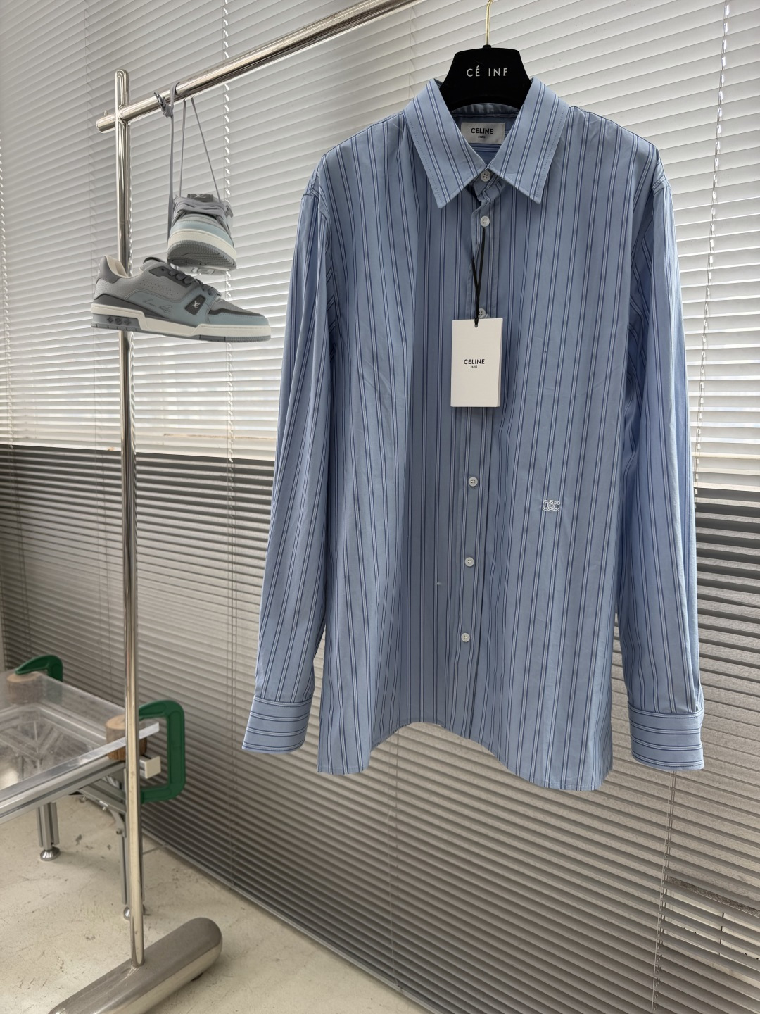 NO:953982,-Celin* classic striped shirt with embroidery is made of 100% cotton poplin fabric. The pure cotton fiber can quickly absorb moisture and perspire, making it refreshing and not stuffy when worn for a long time. The unique plain weaving process of poplin makes the fabric soft and skeletal, not easy to wrinkle and deform, and the upper body is neat and clean. In addition, the whole body is fine and fine blue and white stripes, the light color scheme is gentle and elegant, and can meet the needs of different scenes.  The waist pattern is embroidered using a Tajima high-speed embroidery machine, equipped with a 12-pin position independent control system and a 0.01mm stepper motor, achieving high-speed operation of 1,200 stitches per second. The machine is equipped with an intelligent thread breakage detection function that can automatically stop within 0.3 seconds of thread breakage to avoid stitch misalignment; the tension closed-loop control system adjusts the upper thread in real time  and the bottom thread tension to ensure that the white embroidery thread on the cotton is three-dimensional and full without being tight and wrinkled. The curve of the pattern adopts the minimum stitch length, and the stitch angle changes in real time with the curvature of the curve to form a continuous and smooth line, creating a three-dimensional convex feeling. After the embroidery is completed, high-temperature ironing and thread trimming are performed to ensure that the pattern is smooth and compliant, and it is not easy to fall off or warp after long-term wear.  1. The collar adopts double-layer reinforcement technology, which is not easy to collapse and deform after long-term wear. The curvature of the collar angle is soft, which can modify the neck line without being too sharp. 2. The inner side of the placket has hidden hemming treatment to avoid fabric burrs and enhance structural stability. It is not easy to deform after repeated washing. Size number: 36 38 40 42 Size clothing length, chest and shoulder width 36 7611047 38 7711448 40  7811849 42 79 122 50,,celine,shirts,19860909-Celin* 饰刺绣经典条纹衬衫 选用百分百棉府绸面料,纯棉纤维能快速吸湿排汗,长时间穿着也清爽不闷,府绸独特的平纹织造工艺,让面料兼具柔软度与骨感,不易起皱变形,上身利落干净. 加之通体细密蓝白相间条纹,浅淡配色温柔又显气质,能满足不同场景需求. 腰间处图案绣花采用田岛高速绣花机,搭载12针位独立控制系统与0.01mm级步进电机,实现每秒钟1200针的高速运转.机器配备的智能断线检测功能,能在断线0.3秒内自动停机,避免针脚错位；张力闭环控制系统则实时调节面线与底线张力,确保白色绣线在棉布上既立体饱满又不紧绷起皱.图案的曲线采用最小针距,针迹角度随曲线弧度实时变化,形成连续流畅的线条,打造立体凸起感.刺绣完成后进行高温熨烫与线头修剪,确保图案平整服帖,久穿也不易脱线、起翘. 1.领座采用双层加固工艺,久穿不易塌软变形,领角弧度柔和,既能修饰颈部线条,又不会过于尖锐,利落得体. 2.门襟内侧暗藏包边处理,避免面料毛边,同时增强结构稳定性,多次洗涤也不易变形. 码数:36 38 40 42 尺码衣长胸围肩宽 36 7611047 38 7711448 40 7811849 42 79  122 50,,celine,shirts,,Men's clothing