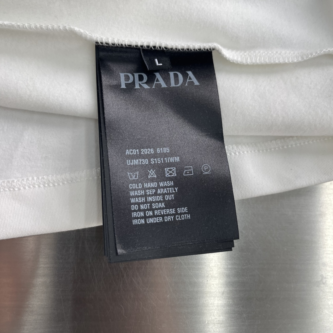 -PRAD 2026秋冬圆领绣花短袖T恤打底衫 元素性的Logo徽章凸显休闲时尚魅力,依然独领时尚风骚.内搭好伴侣 -PRAD 2026秋冬圆领绣花短袖T恤打底衫 元素性的Logo徽章凸显休闲时尚魅力,依然独领时尚风骚.内搭好伴侣