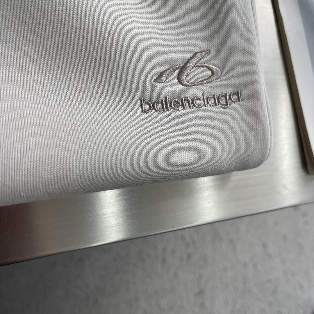 -Balenciag     双色绣花细节抓绒卫裤 左腿前侧偏上位置，一个环形的b字logo+balenciag*小写全