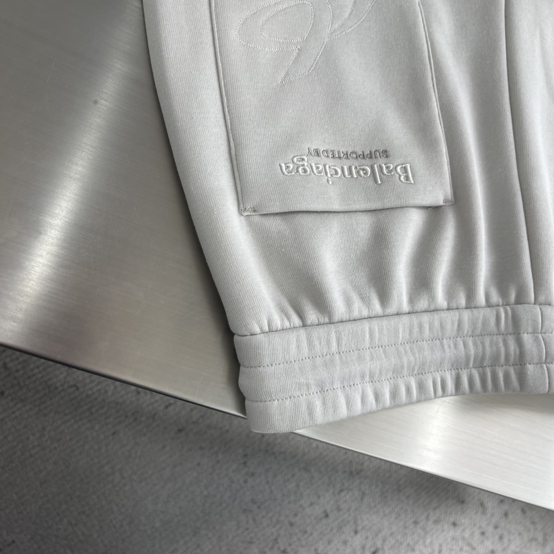 -Balenciag     双色绣花细节抓绒卫裤 左腿前侧偏上位置，一个环形的b字logo+balenciag*小写全