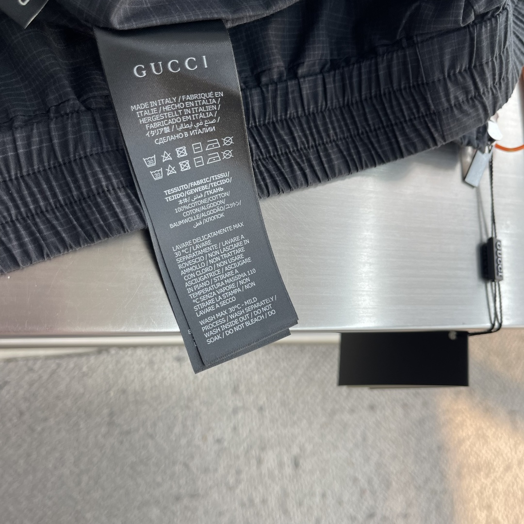 -GUCC     徽章刺绣格纹外套 定制格纹长绒棉梭织尼龙料 肌理细密 柔韧贴体 幽炭灰调裹覆衣身 同调暗纹低调铺展 