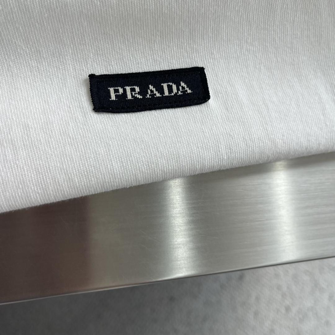 -PRAD     徽标标签长袖 定制砚序柔芯素织棉 纤理绵密 温润凝柔 凝霜素白涤尽浮华 铺展清简自持的静奢底蕴 经典