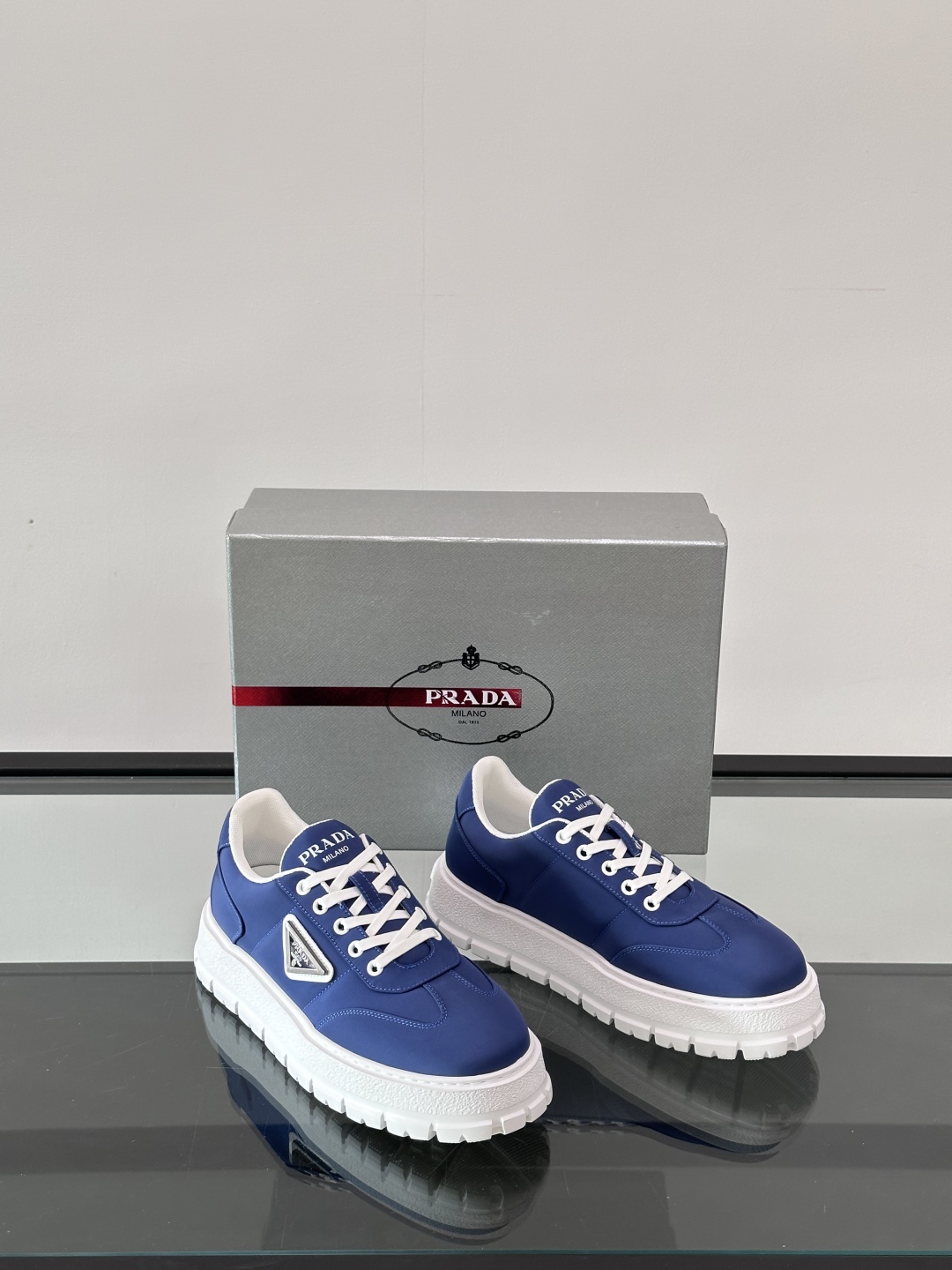 Prada/普拉达 男士新款运动休闲鞋，这款运动鞋鞋面采用科技面料。外侧饰以P家经典金属三角珐琅徽标，真