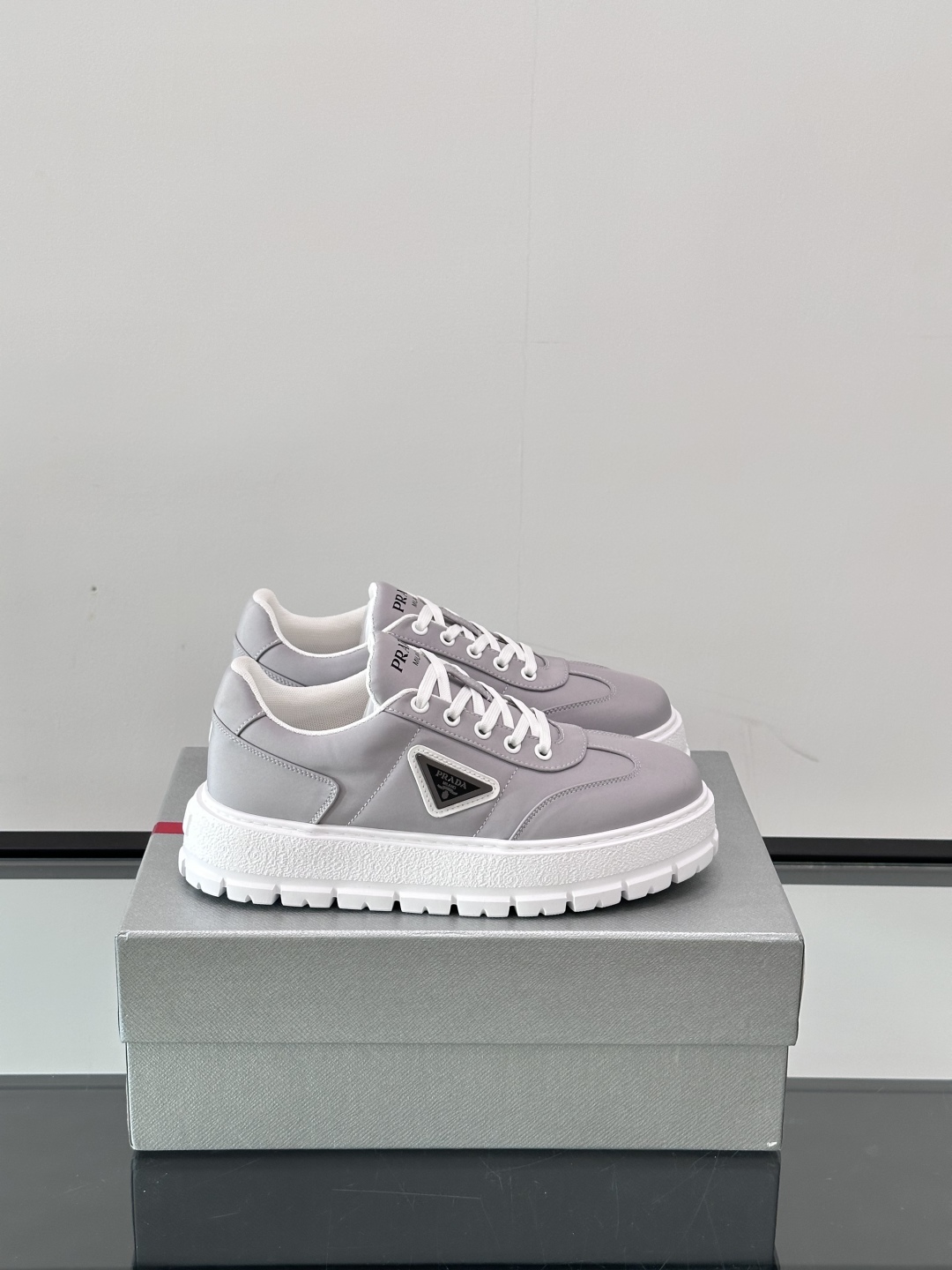 Prada/普拉达 男士新款运动休闲鞋，这款运动鞋鞋面采用科技面料。外侧饰以P家经典金属三角珐琅徽标，真