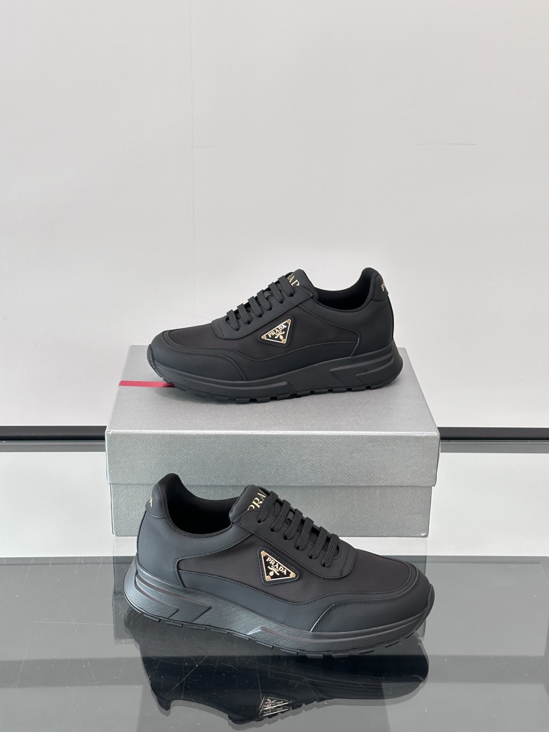 Prada/普拉达 男士新款运动休闲鞋，这款运动鞋鞋面采用进口小牛皮。外侧饰以P家经典金属三角珐琅徽标，