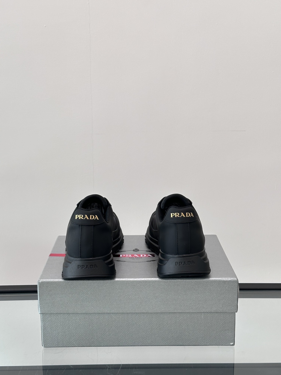 Prada/普拉达 男士新款运动休闲鞋，这款运动鞋鞋面采用进口小牛皮。外侧饰以P家经典金属三角珐琅徽标，