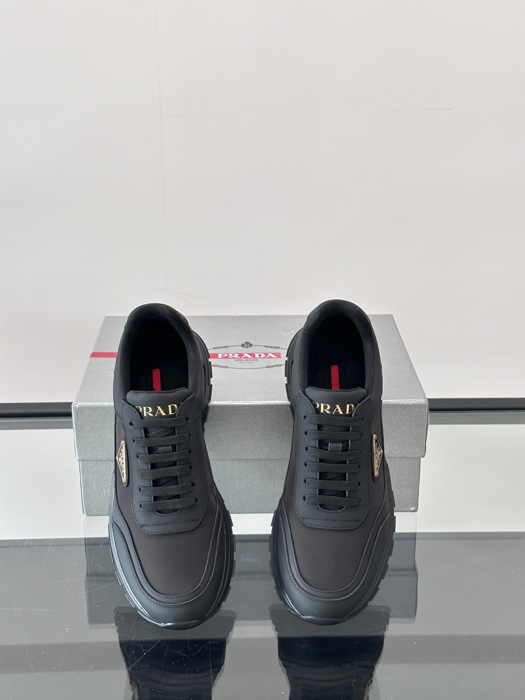Prada/普拉达 男士新款运动休闲鞋，这款运动鞋鞋面采用进口小牛皮。外侧饰以P家经典金属三角珐琅徽标，
