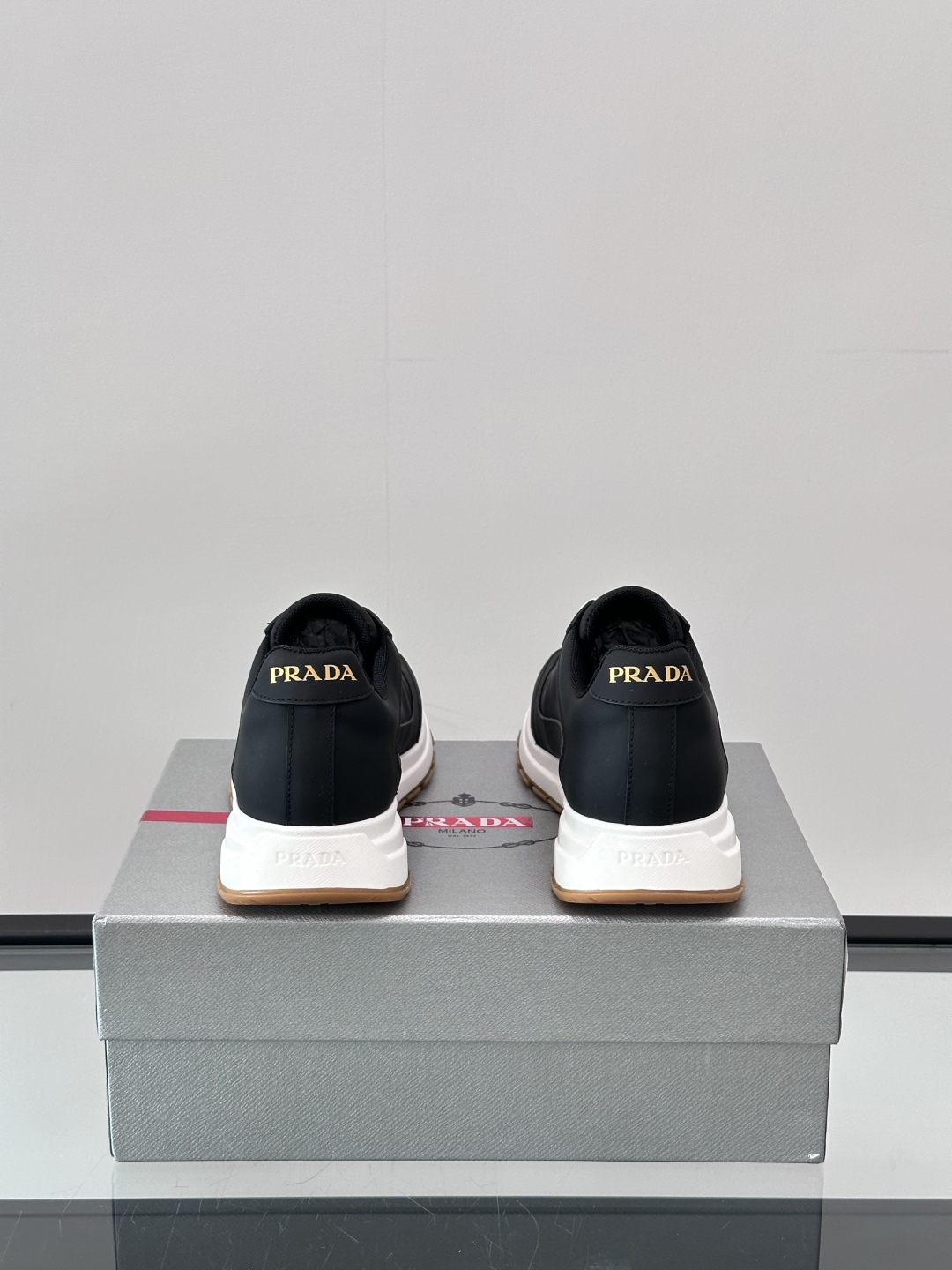 Prada/普拉达 男士新款运动休闲鞋，这款运动鞋鞋面采用进口小牛皮。外侧饰以P家经典金属三角珐琅徽标，