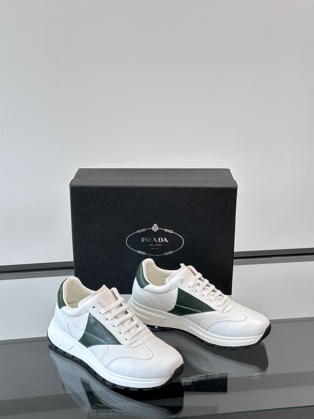 Prada/普拉达 男士新款运动休闲鞋，这款运动鞋鞋面采用进口小牛皮。外侧饰以彩色经典三角图案，真皮内里