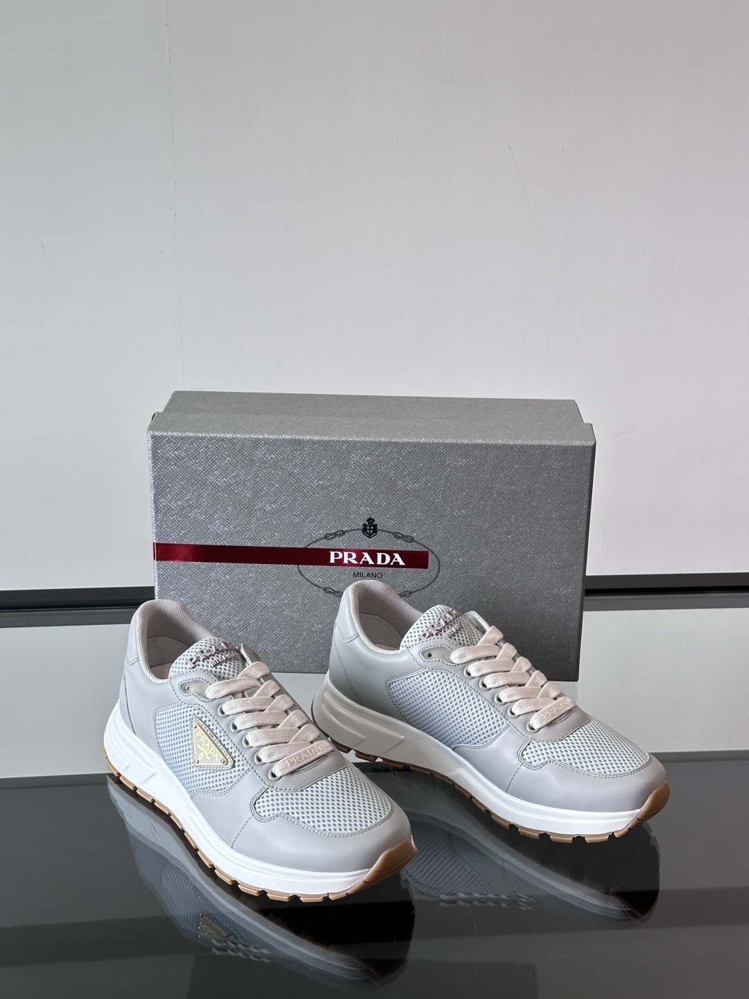 Prada/普拉达 男士新款运动休闲鞋，这款运动鞋鞋面采用进口小牛皮拼接透气网面，外侧饰以P家经典金属三