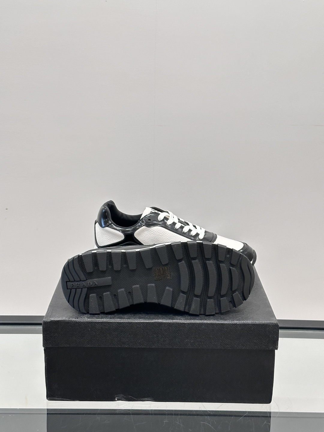 Prada/普拉达 男士新款运动休闲鞋，这款运动鞋鞋面采用进口小牛皮，外侧饰以P家经典金属三角珐琅徽标，