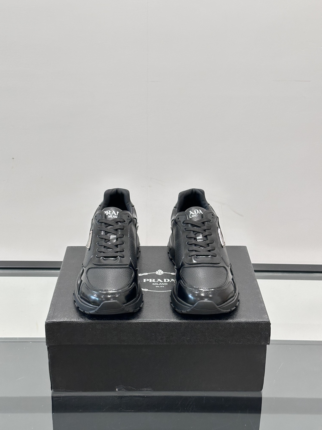 Prada/普拉达 男士新款运动休闲鞋，这款运动鞋鞋面采用进口小牛皮，外侧饰以P家经典金属三角珐琅徽标，