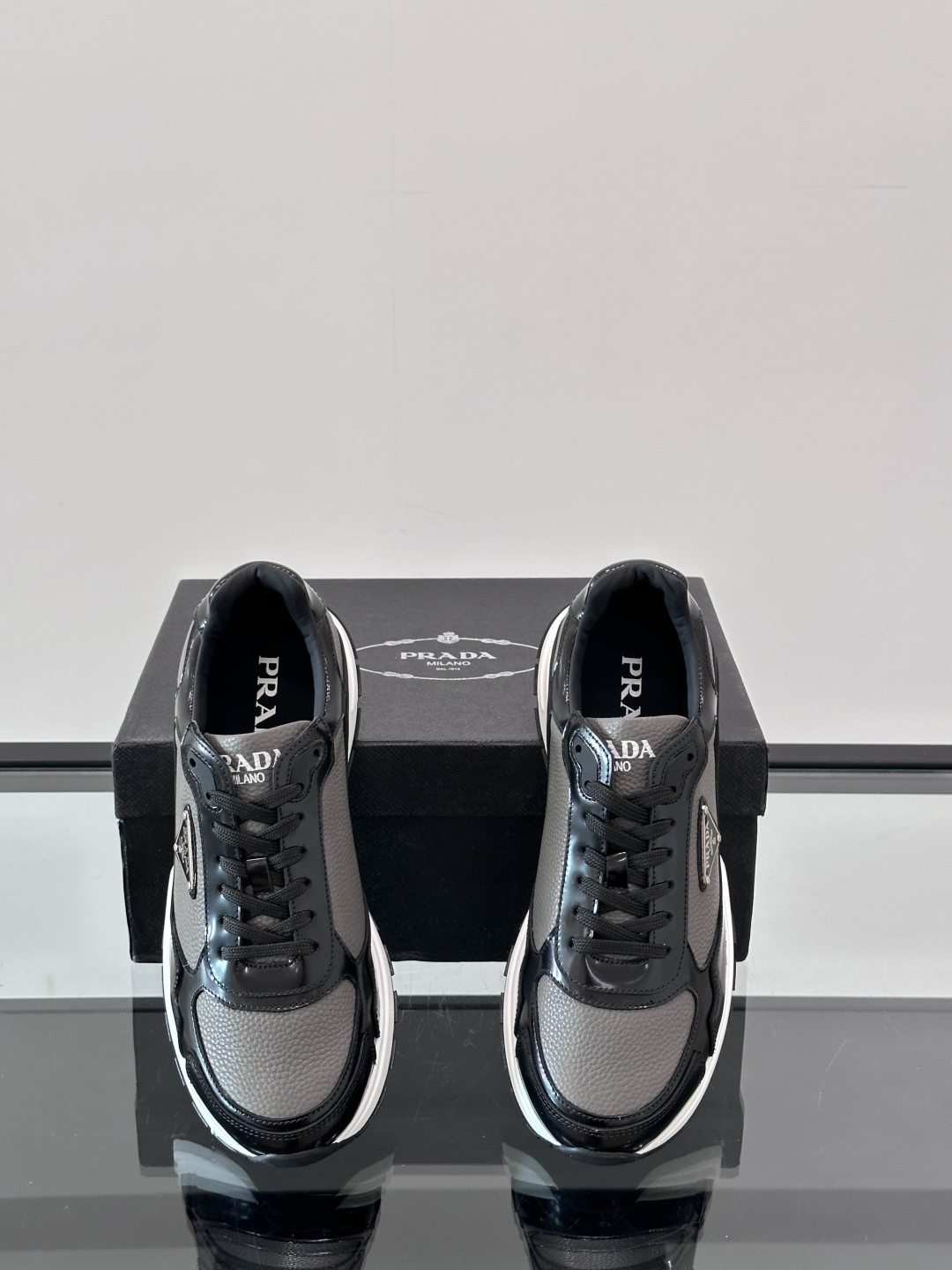 Prada/普拉达 男士新款运动休闲鞋，这款运动鞋鞋面采用进口小牛皮，外侧饰以P家经典金属三角珐琅徽标，