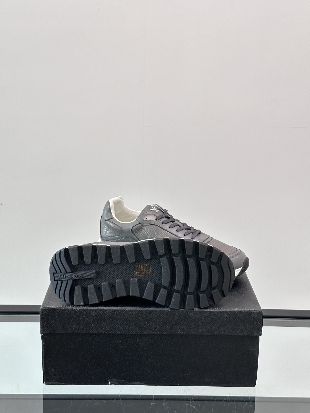 Prada/普拉达 男士新款运动休闲鞋，这款运动鞋鞋面采用进口小牛皮，外侧饰以P家经典金属三角珐琅徽标，