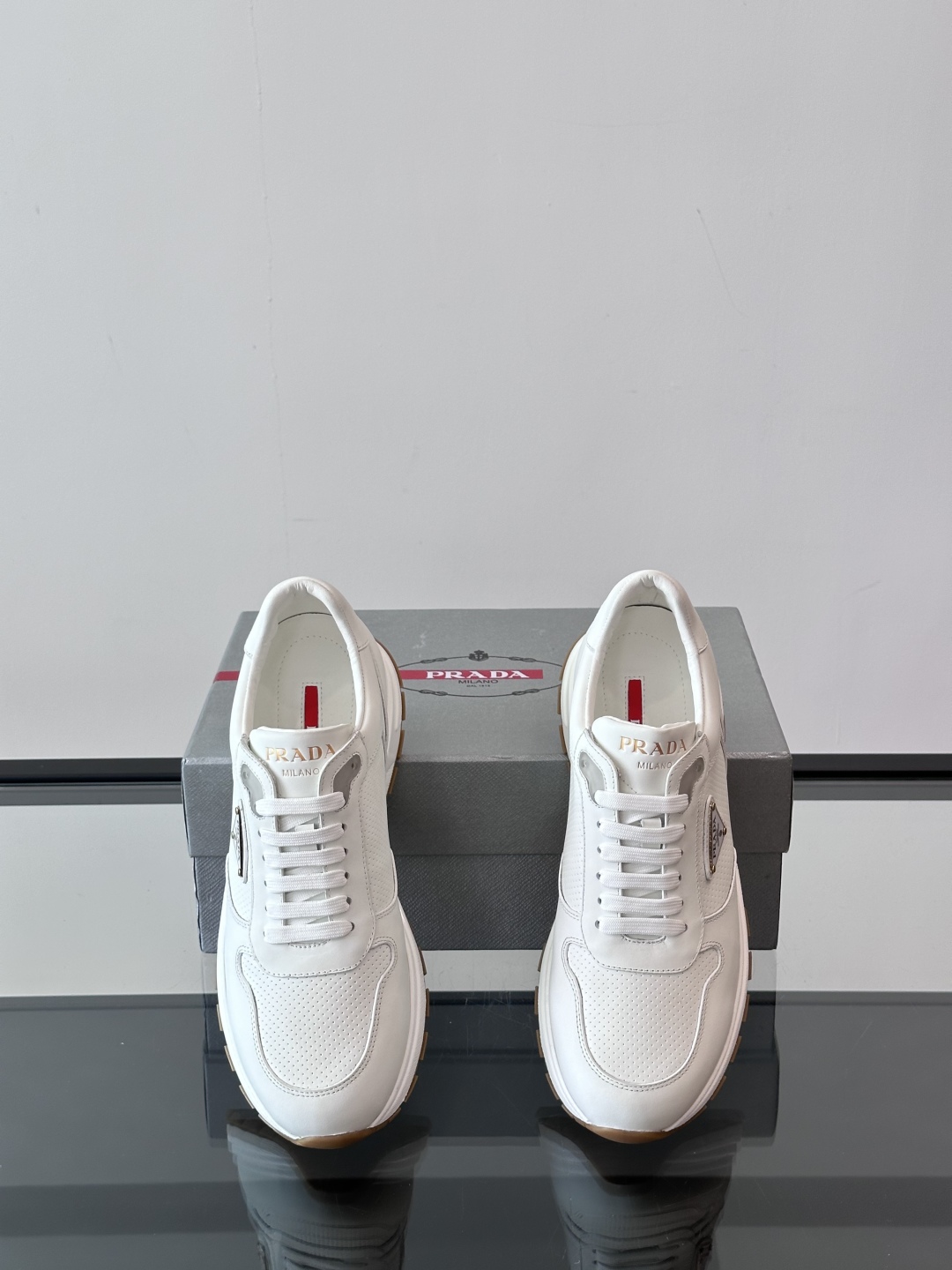Prada/普拉达 男士新款运动休闲鞋，这款运动鞋鞋面采用进口小牛皮。外侧饰以P家经典金属三角珐琅徽标，