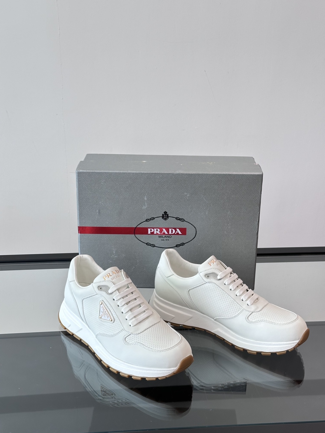 Prada/普拉达 男士新款运动休闲鞋，这款运动鞋鞋面采用进口小牛皮。外侧饰以P家经典金属三角珐琅徽标，